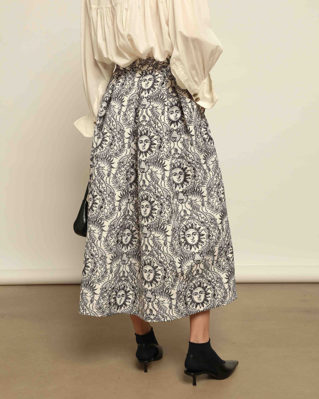 Model is wearing Sun Black and White Skirt by Lunatica Milano. Romantic floral skirt in classic black and white. Elegant, feminine, and handcrafted in Italy. Part of House of Woven Stories selection.