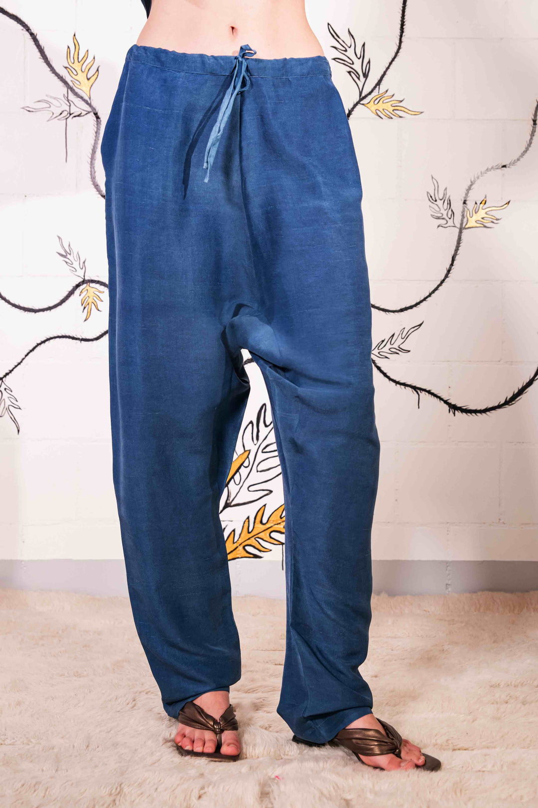 Model is wearing the Everyday Indigo Drawstring Pants with matching Cave Shirt, both in natural dyed silk by A Sacred Wrap. Handcrafted and botanically dyed, this look is available at House of Woven Stories.