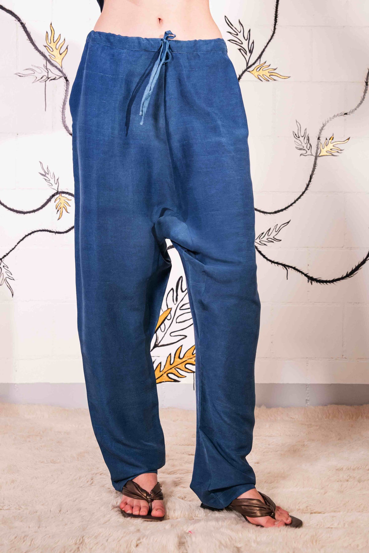 Model is wearing the Everyday Indigo Drawstring Pants with matching Cave Shirt, both in natural dyed silk by A Sacred Wrap. Handcrafted and botanically dyed, this look is available at House of Woven Stories.