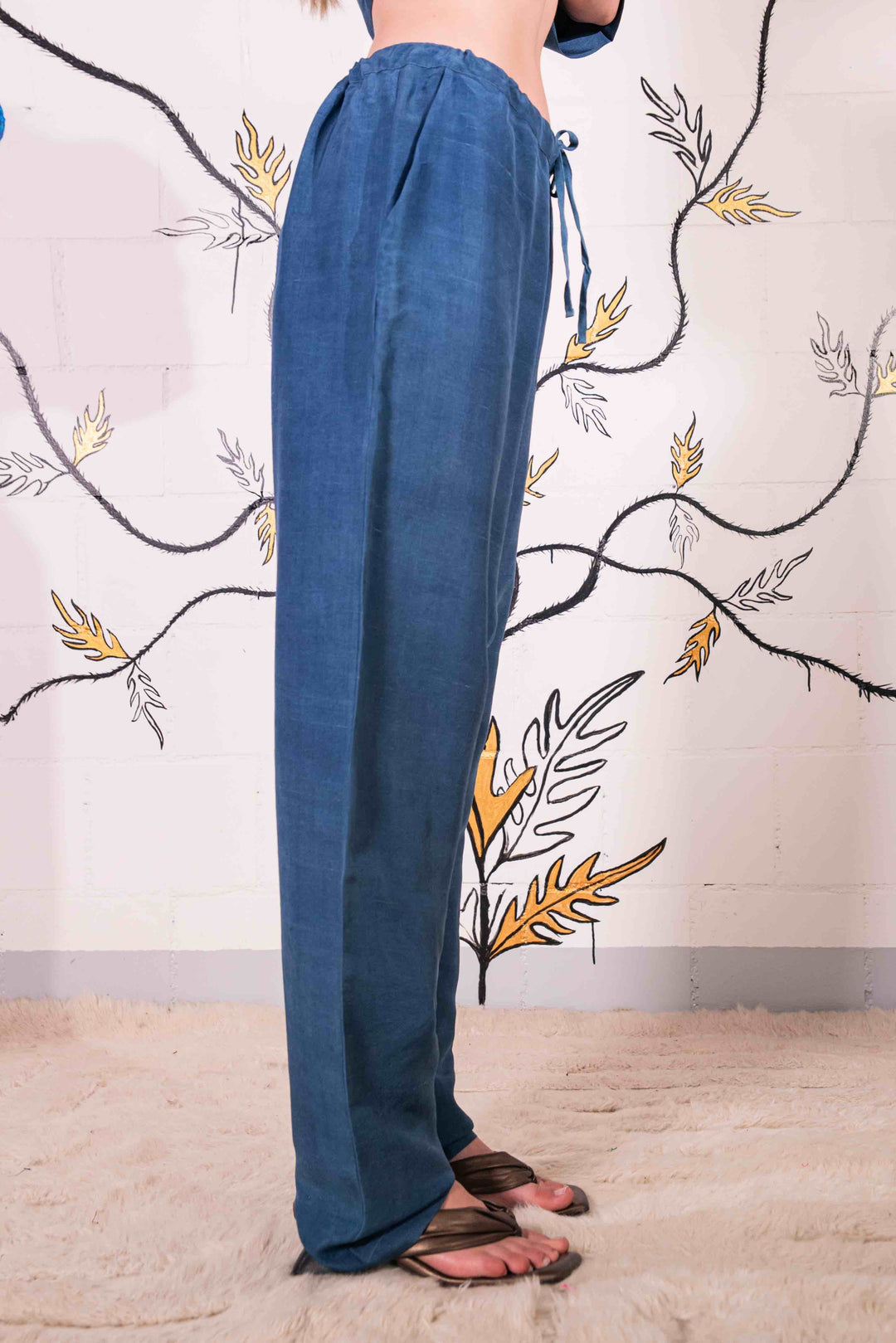 Model is wearing the Everyday Indigo Drawstring Pants with matching Cave Shirt, both in natural dyed silk by A Sacred Wrap. Handcrafted and botanically dyed, this look is available at House of Woven Stories.