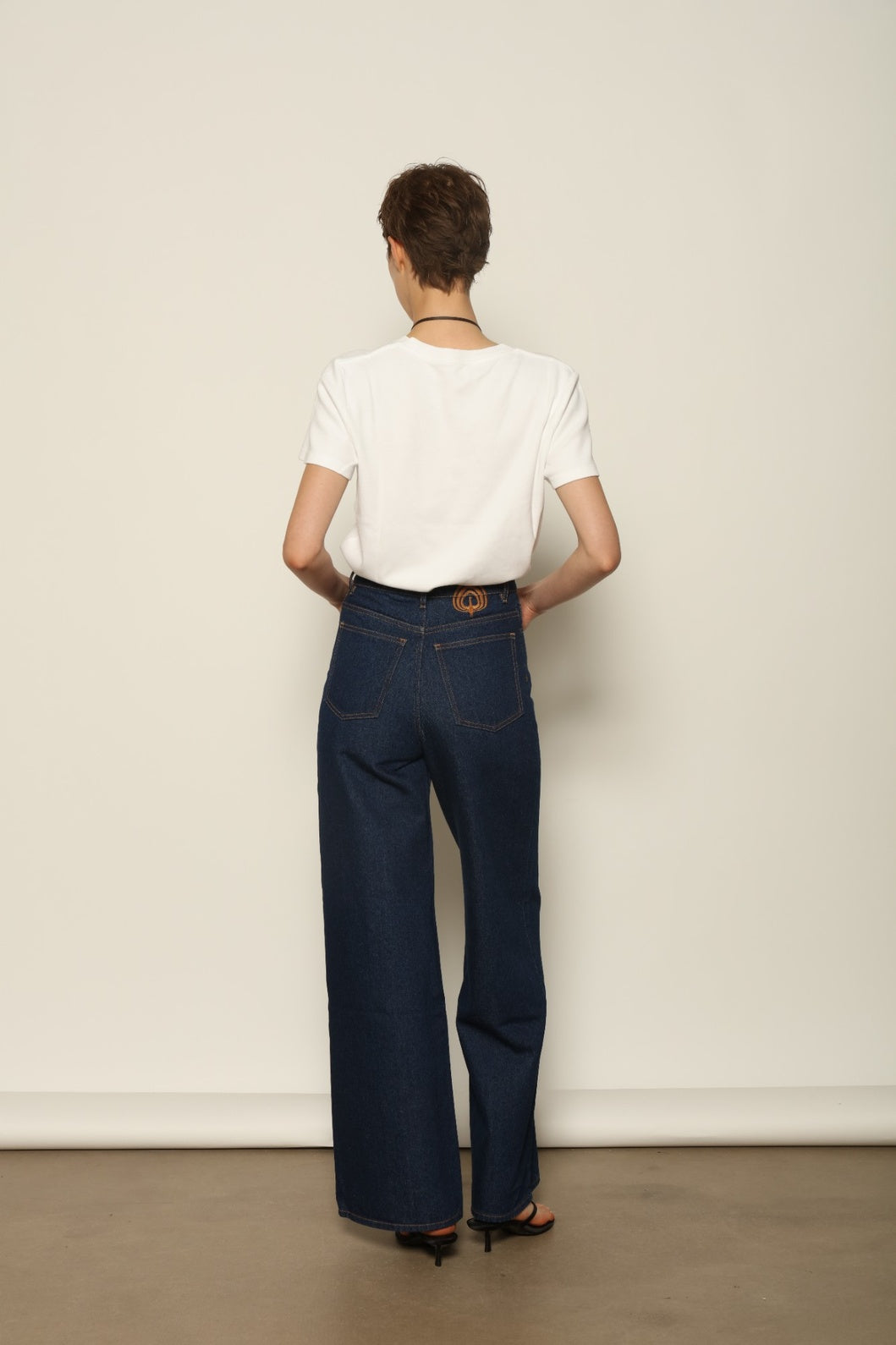 Back view of Le Pantalon Peacock by HAPPY HAUS, highlighting the double stitched pockets and embroidered detail.