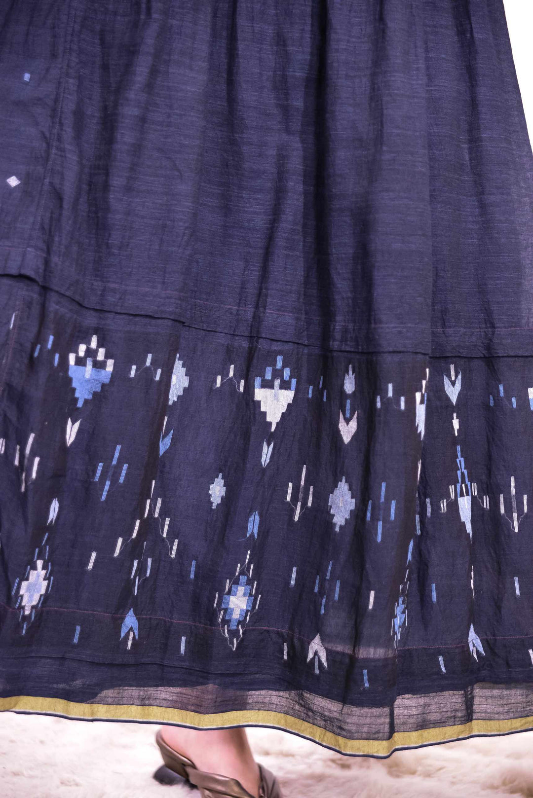 Fine pistachio line at the hem of the Amber 73 Slip Dress by Injiri, woven from naturally dyed organic cotton in deep indigo, curated by House of Nomad Stories.