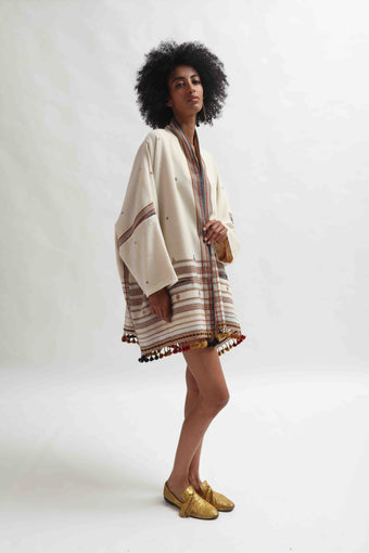 Model wearing the Kyoto Kimono Jacket in off-white handwoven merino wool with natural indigo patterns, lined in pure silk. Oversized fit, artisanal details, and bohemian elegance by House of Woven Stories.