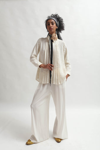 Leno Pleated Shirt by Paiwand made from upcycled cotton with breathable leno weave, featuring elegant pleats and handcrafted in India. Sustainable fashion curated by House of Nomad Stories.