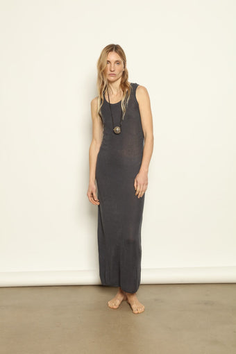 Indigo Ribbed Dress by Mirror in the Sky handcrafted in Nepal from 100% pure cashmere. Woman wearing a long dark dress against a plain background