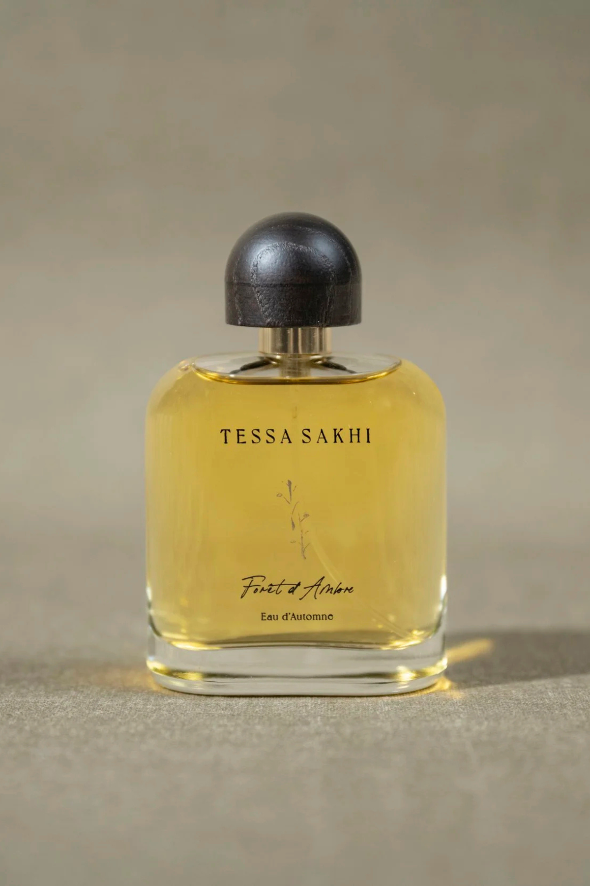 Bottle of Forêt d’Ambre – Eau d’Automne by Tessa Sakhi, a unisex amber and woody Eau de Parfum with notes of white pepper, patchouli, labdanum, tonka bean, and musk. A balancing and soothing fragrance curated by House of Nomad Stories.