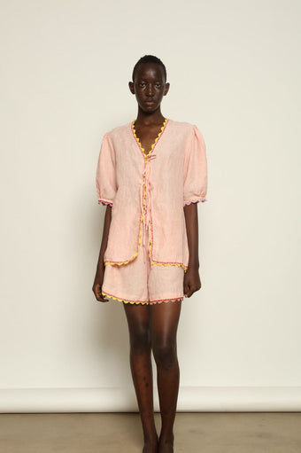 Model is wearing the Agata Pink Linen Set by Supernaturae x HONS, crafted in lightweight washed linen with soft botanical pink tones and delicate hand-crochet detailing. This sustainable summer capsule piece features a relaxed, breathable silhouette designed for effortless movement and timeless styling. Made in small-batch ethical production in Mexico, part of the House of Nomad Stories selection, worn by model 1.79m tall.
