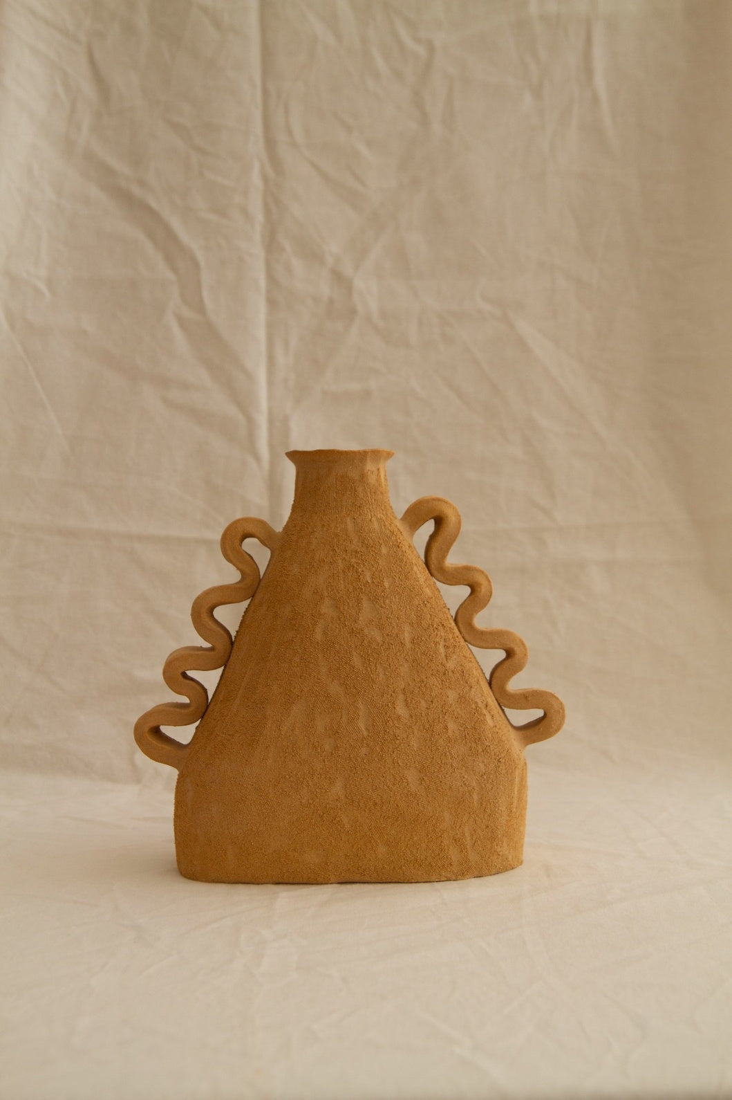 Handbuilt Amphora Soleil in sun-toned chamotte clay by Clandestine Céramique, featuring sculptural handles and a textured surface, available at House of Woven Stories.