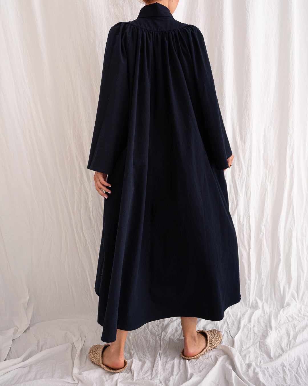 A Bigger Splash Cotton Dress by Les Vacances d’Irina, full-length long-sleeved maxi dress in ivory cotton with shell buttons, high collar, and hidden side pockets, handmade in Romania.