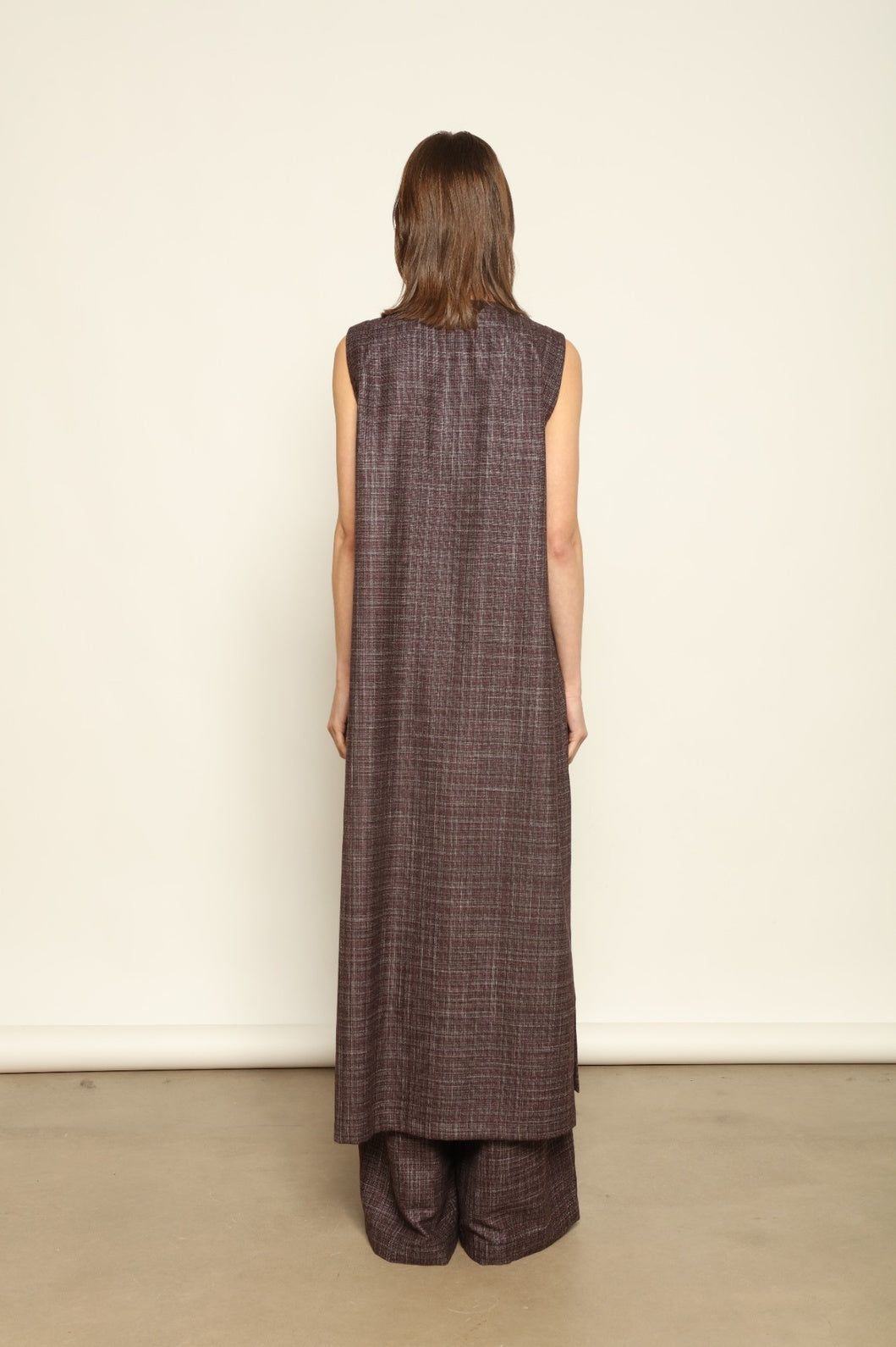Model is wearing the Athen Burgundy Tunic Dress by House of Woven Stories, made from a wool, silk, and cashmere blend with longline silhouette and deep V-neck.