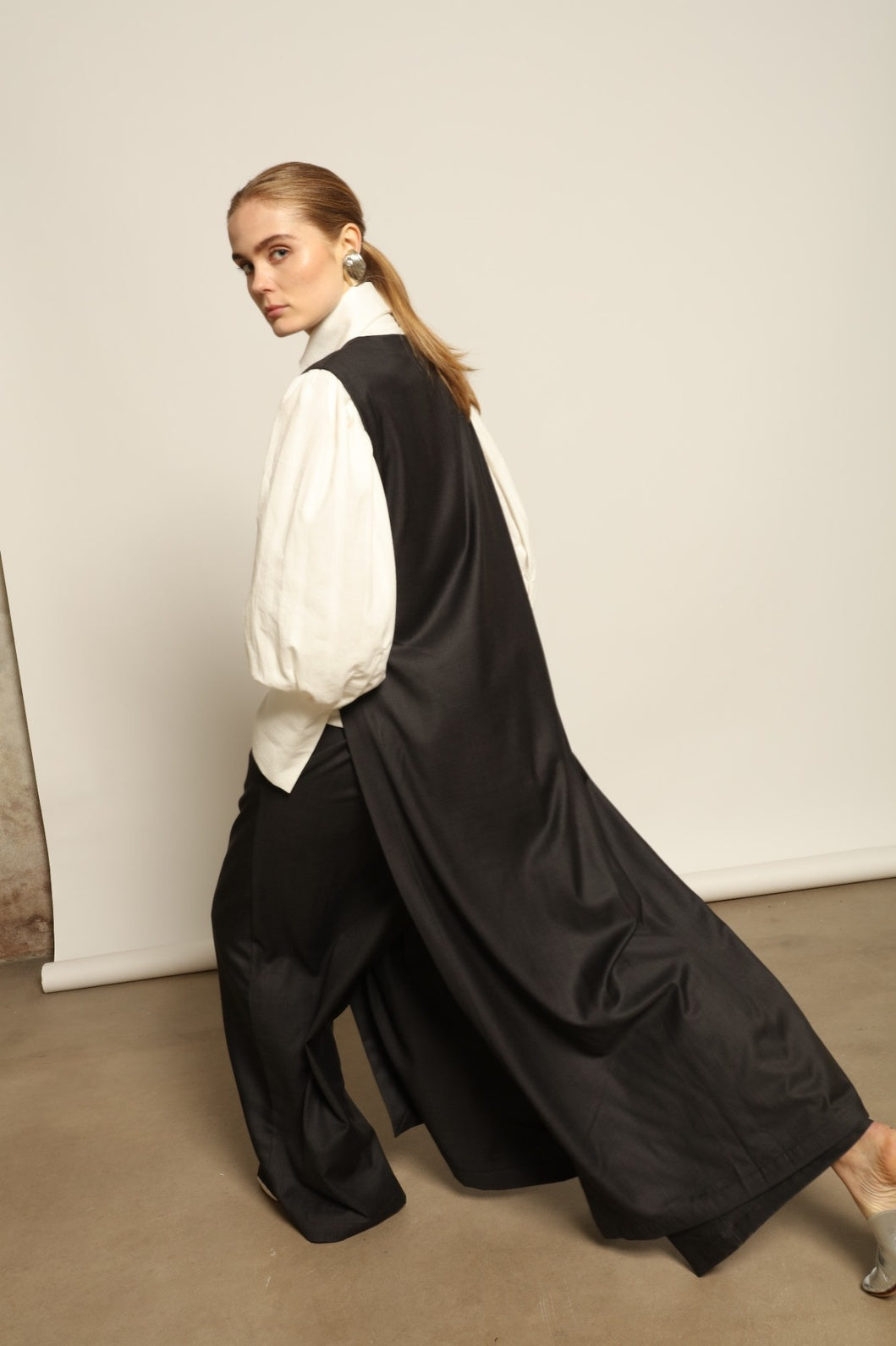 Model is wearing the Athen Twill Tunic Dress by House of Nomad Stories, styled as an elongated layered piece with a relaxed silhouette and open sides.