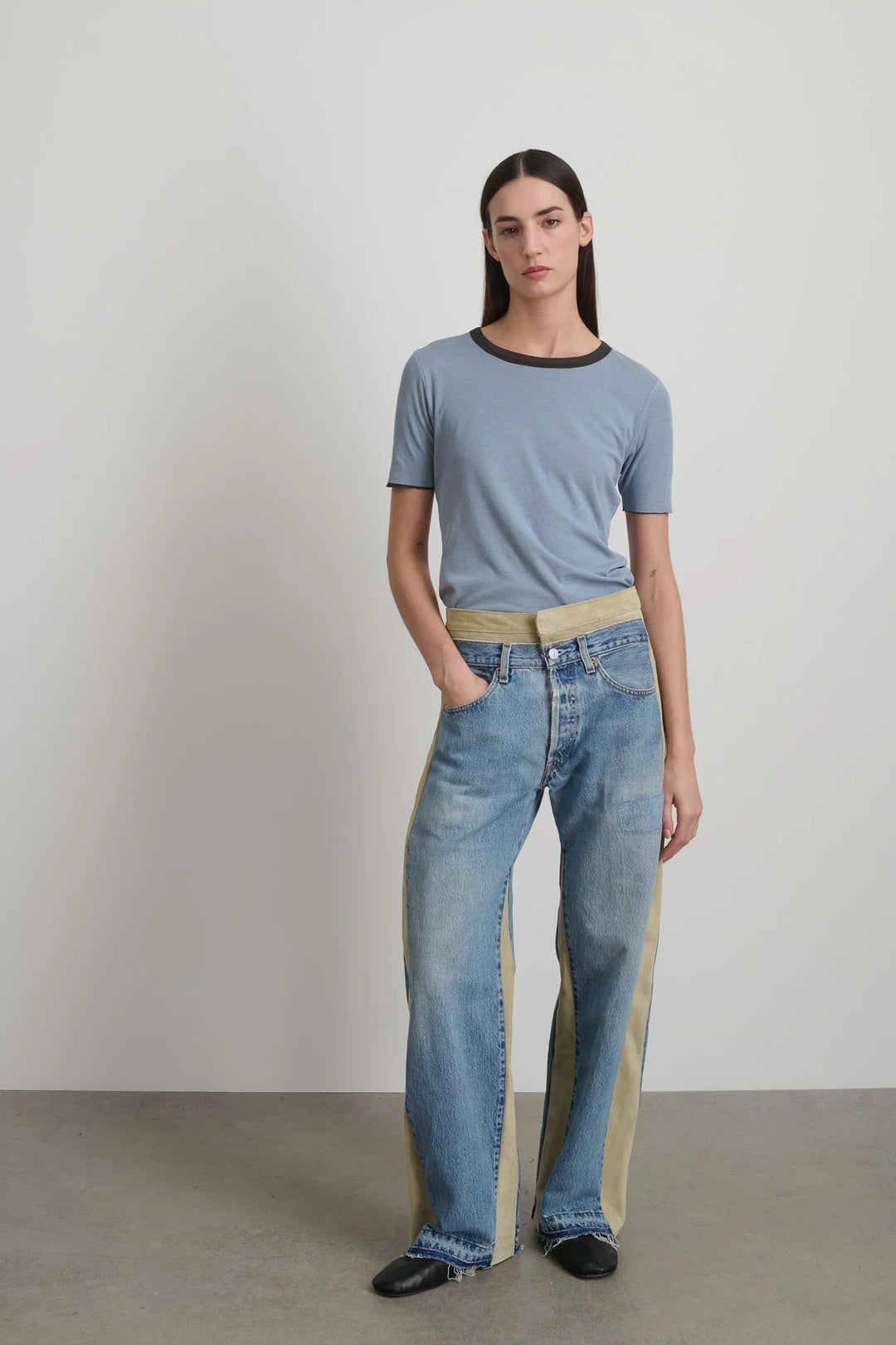 Model is wearing B Sides Double Waistband Rework Jeans in vintage indigo denim with Italian calf suede waistband, mid-rise relaxed fit, 30-inch inseam, unique fade and details, from the curated selection of House of Woven Stories