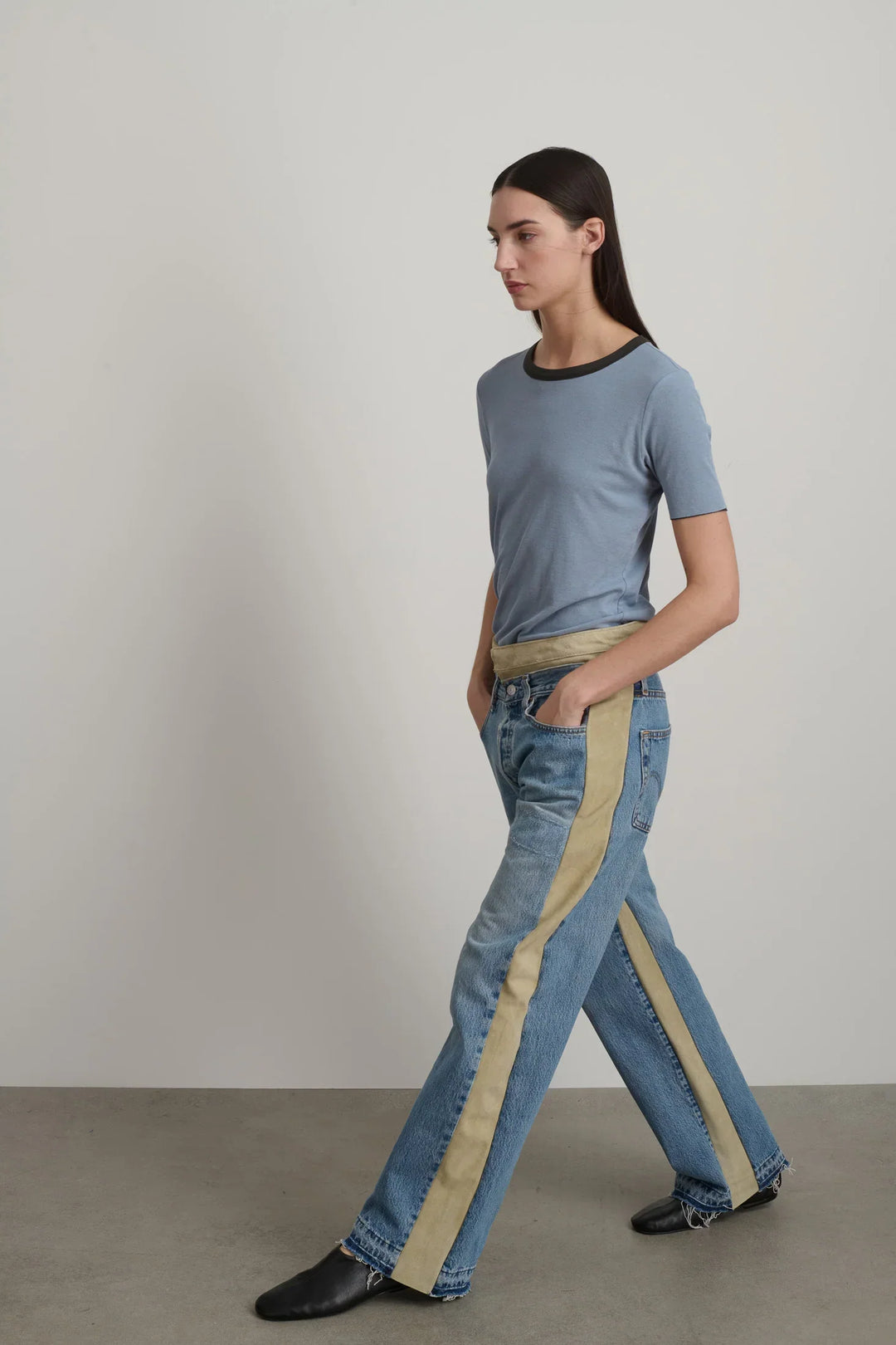 Model is wearing B Sides Double Waistband Rework Jeans in vintage indigo denim with Italian calf suede waistband, mid-rise relaxed fit, 30-inch inseam, unique fade and details, from the curated selection of House of Woven Stories