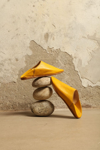 Model is wearing the Baboush in Yellow Leather by House of Nomad Stories, handcrafted in Marrakesh from ethically sourced leather with a warm yellow hue, cushioned sole, and timeless Moroccan design.