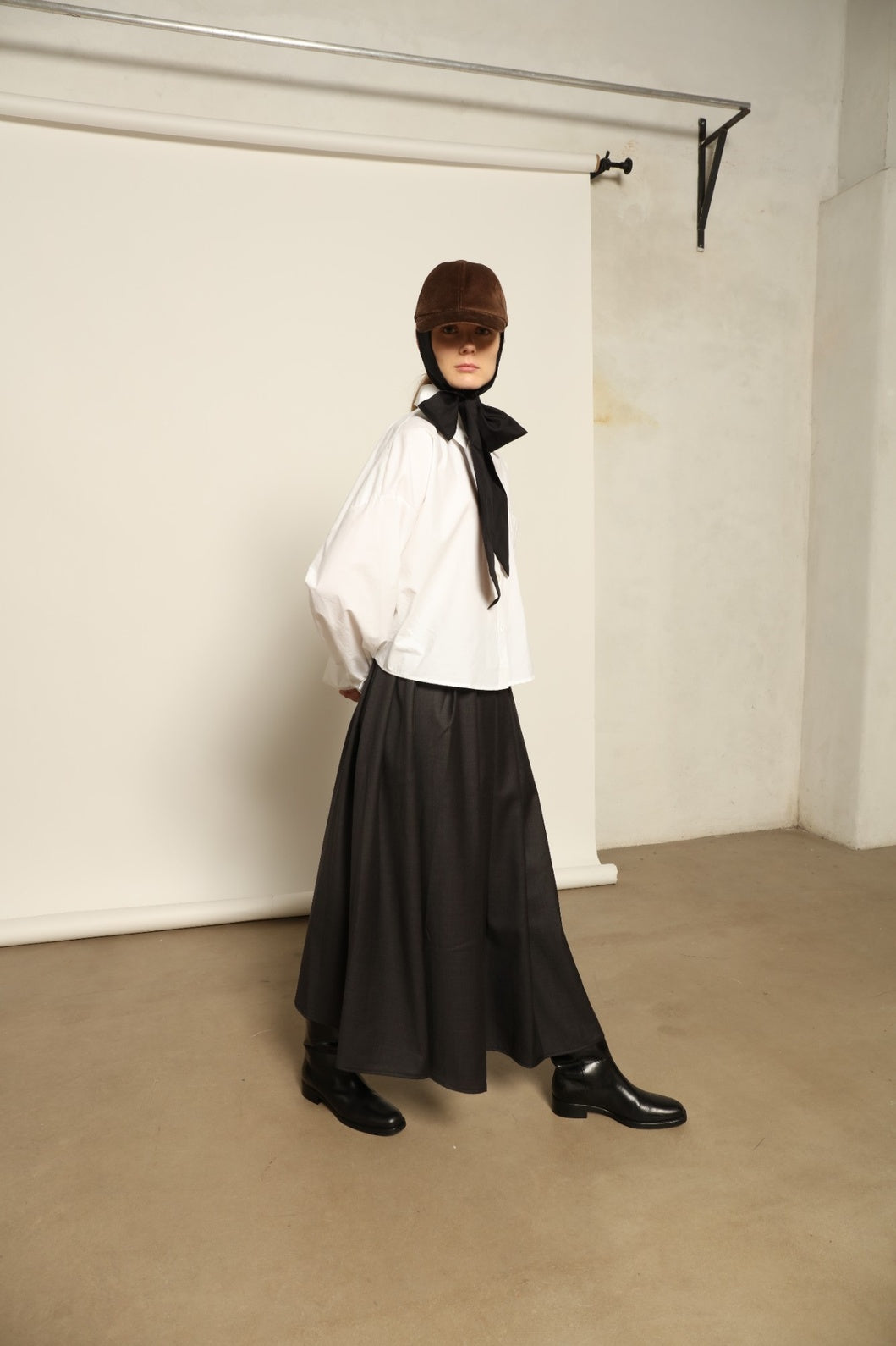 Model is wearing the Bettina White Organic Cotton Blouse by House of Nomad Stories, featuring a straight silhouette, classic collar, button-front closure, and oversized chest pocket.