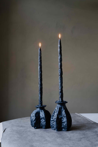 Carambola Low in Black candle holder by Oberflacht, part of the House of Nomad Stories selection, handmade from beeswax and paraffin with matching twig candle and natural variations in colour and texture.