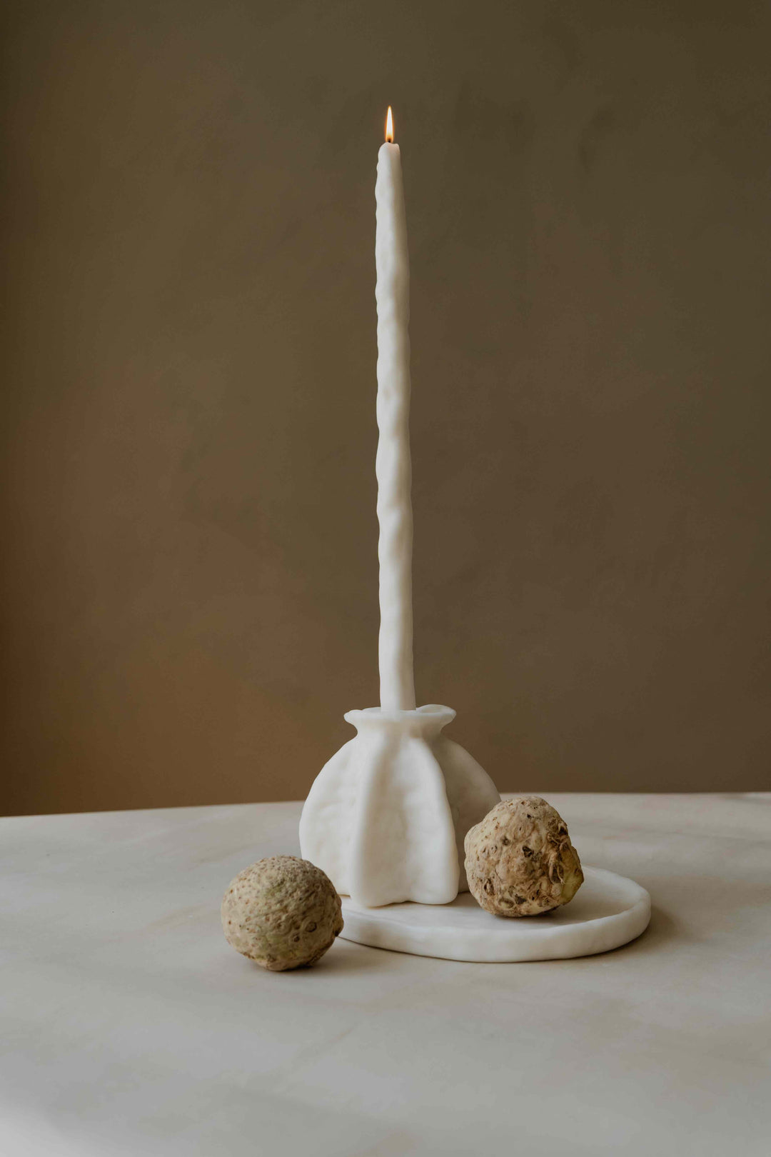 Carambola Low in Cream candle holder by Oberflacht, part of the House of Nomad Stories selection, handcrafted from beeswax and paraffin with matching twig candle and subtle variations in colour, shape, and texture.