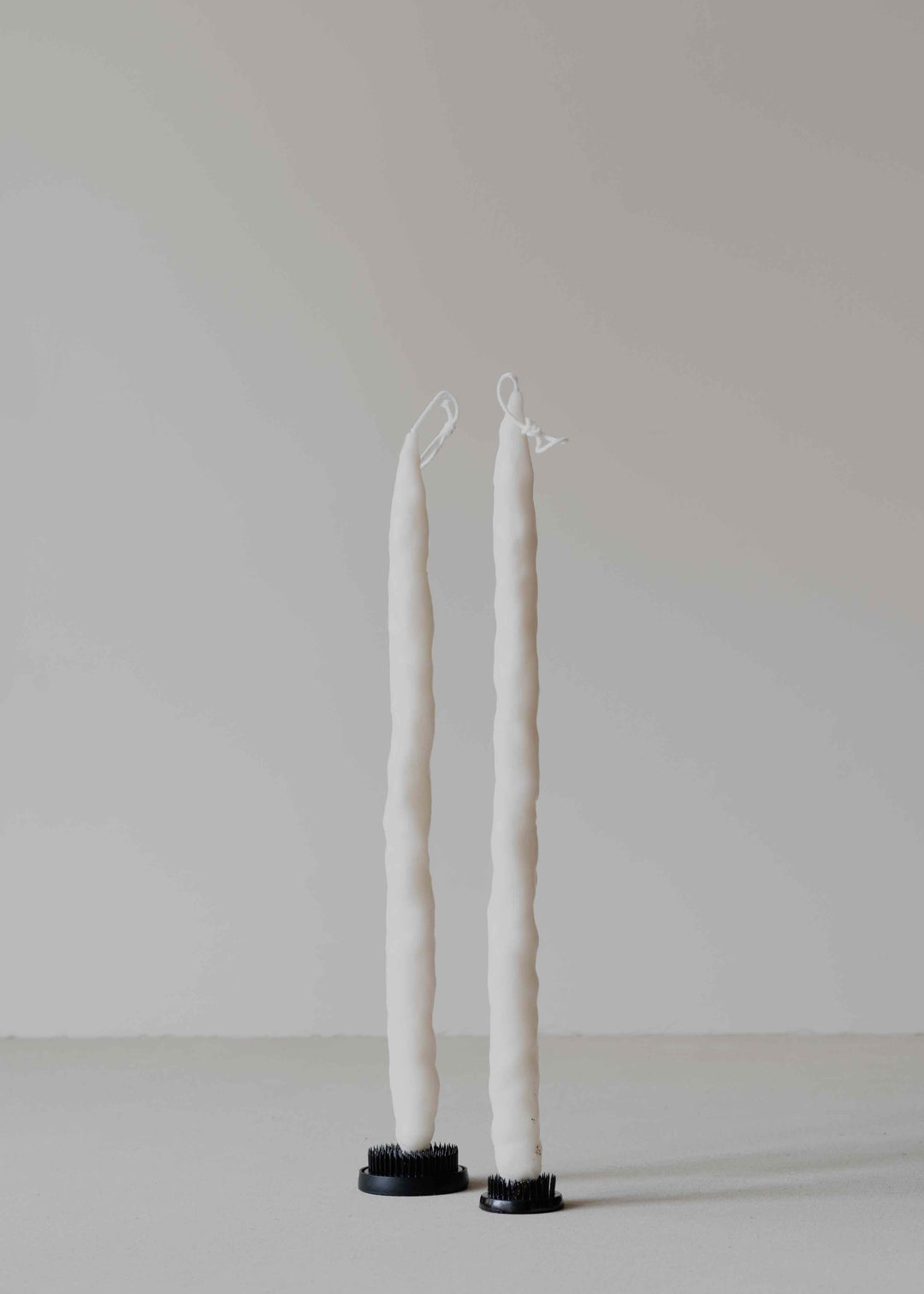 Carambola Low in Cream candle holder by Oberflacht, part of the House of Nomad Stories selection, handcrafted from beeswax and paraffin with matching twig candle and subtle variations in colour, shape, and texture.