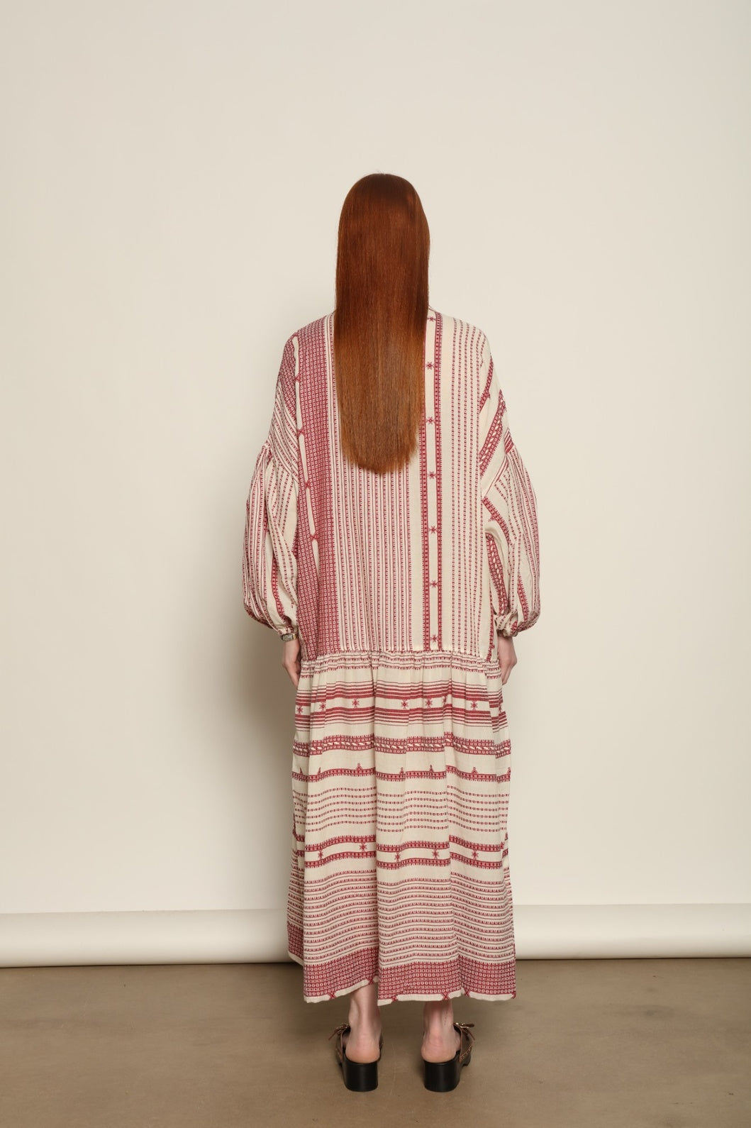 Model is wearing the Cherry Red Chemena Dress by House of Woven Stories, a relaxed 100% organic handspun Kahla cotton dress crafted in Gujarat, India, with a fluid silhouette and effortless, feminine character.