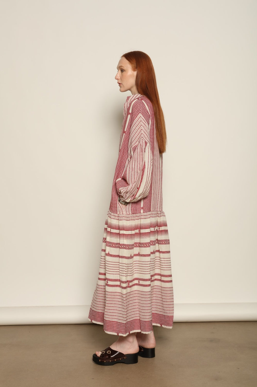 Model is wearing the Cherry Red Chemena Dress by House of Woven Stories, a relaxed 100% organic handspun Kahla cotton dress crafted in Gujarat, India, with a fluid silhouette and effortless, feminine character.