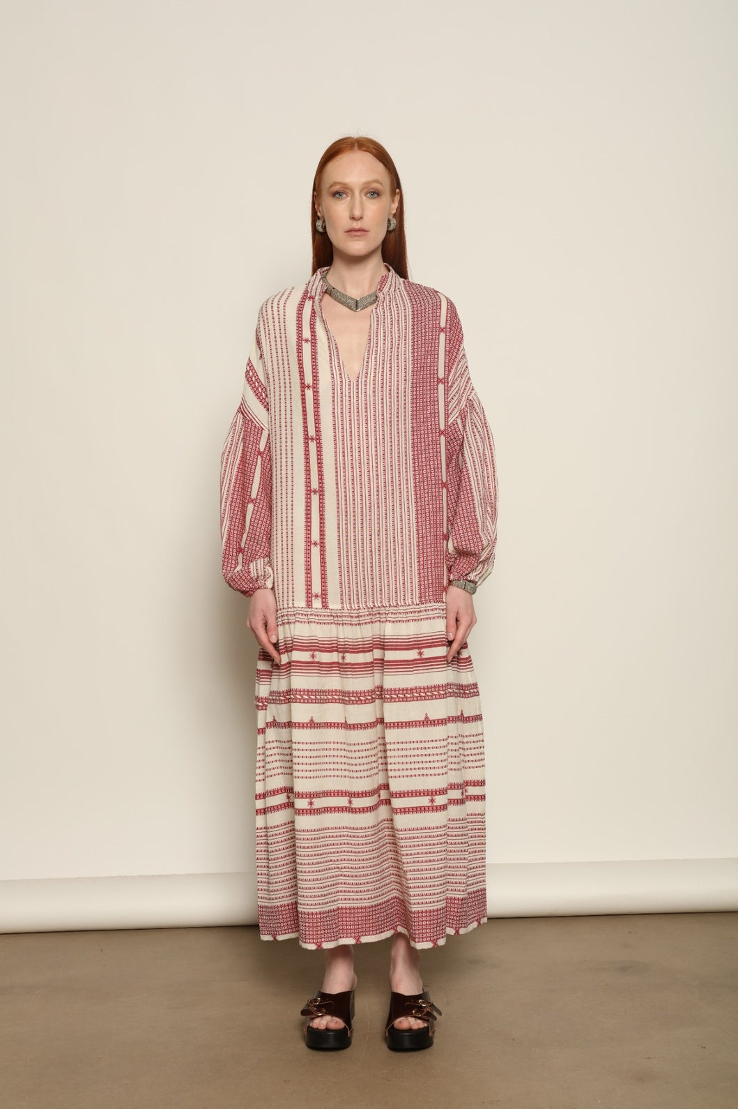 Model is wearing the Cherry Red Chemena Dress by House of Woven Stories, a relaxed 100% organic handspun Kahla cotton dress crafted in Gujarat, India, with a fluid silhouette and effortless, feminine character.