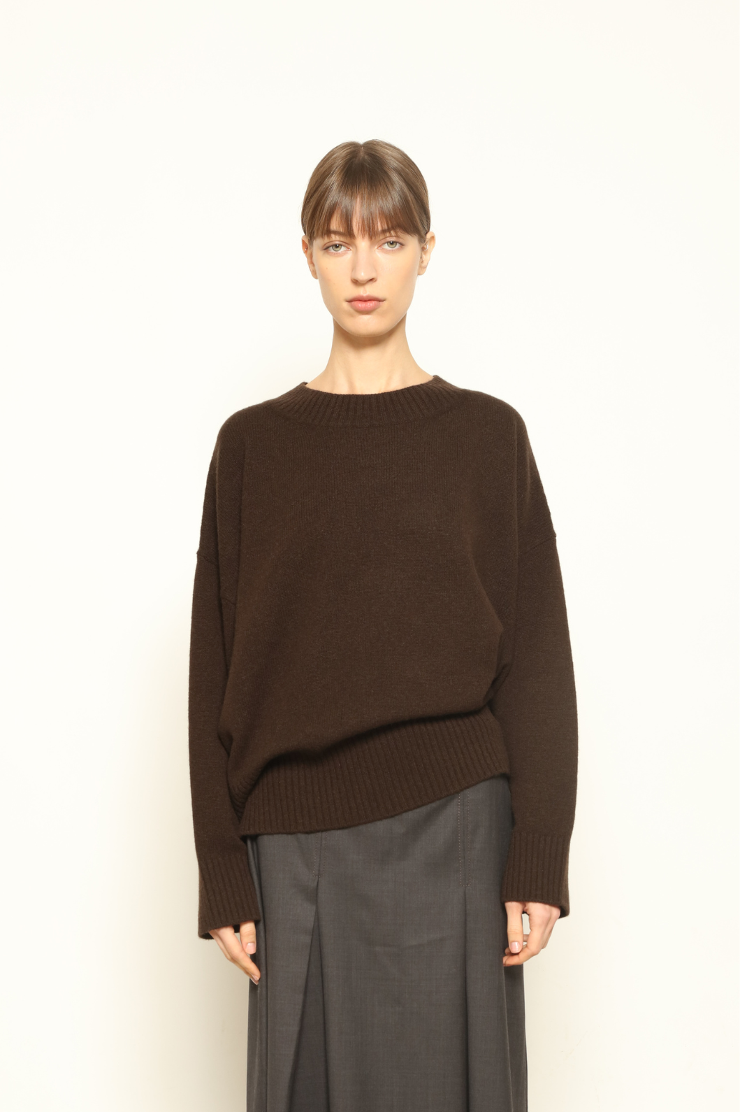 Model is wearing the chocolate Noemi Round Neck Pullover by House of Nomad Stories, made from 100% pure Inner Mongolia cashmere, featuring ultra-soft, breathable, durable knitwear, relaxed fit, and timeless luxury craftsmanship