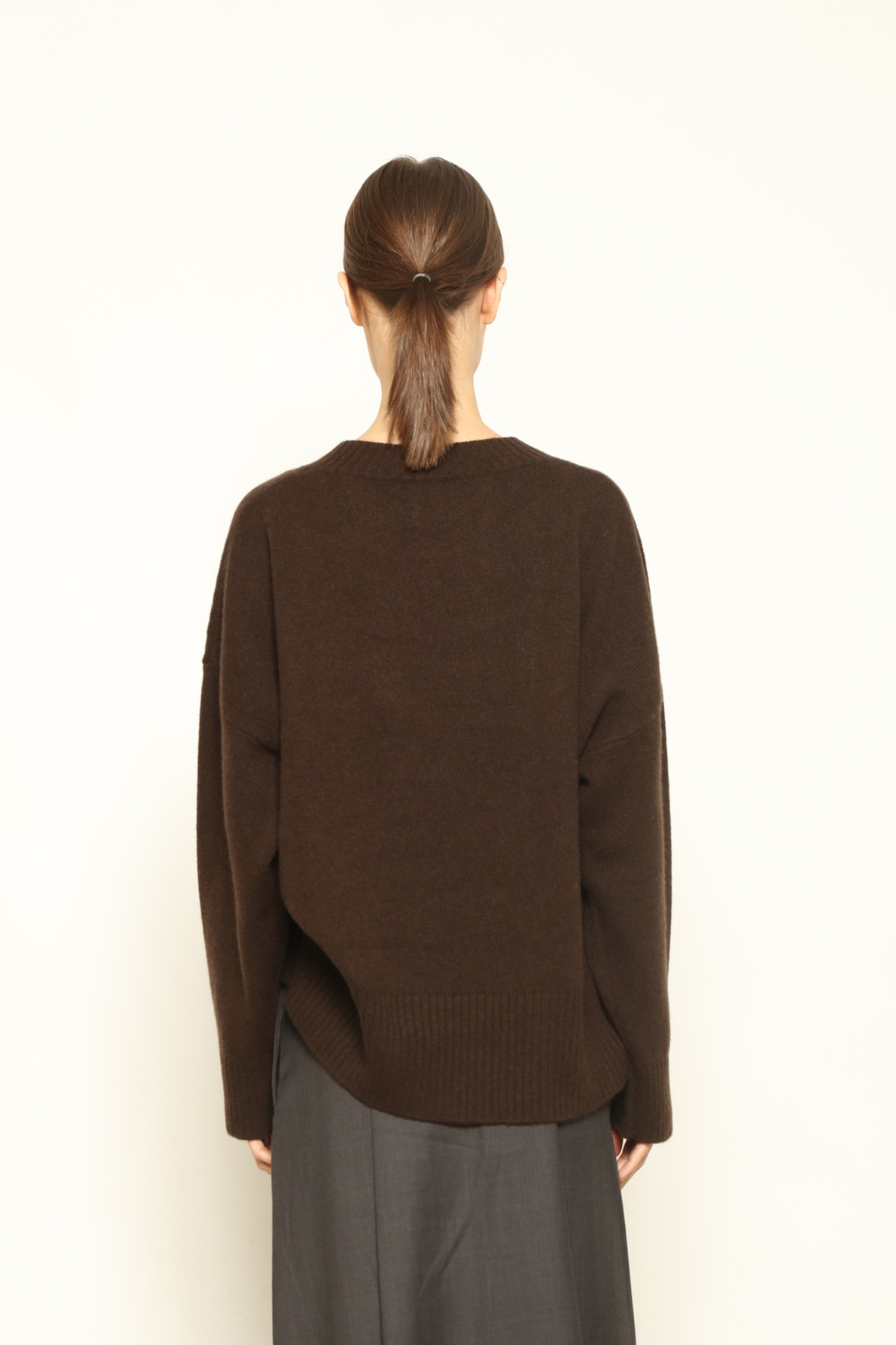 Model is wearing the chocolate Noemi Round Neck Pullover by House of Nomad Stories, made from 100% pure Inner Mongolia cashmere, featuring ultra-soft, breathable, durable knitwear, relaxed fit, and timeless luxury craftsmanship