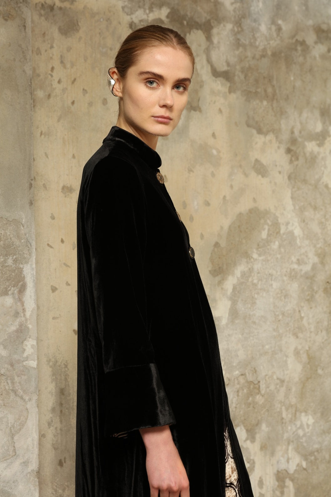 Model is wearing the Cleo Black Long Jacket VR.40 by Obidi, crafted from luxurious velvet with a structured silhouette and refined texture, combining artisanal craftsmanship with contemporary style.
