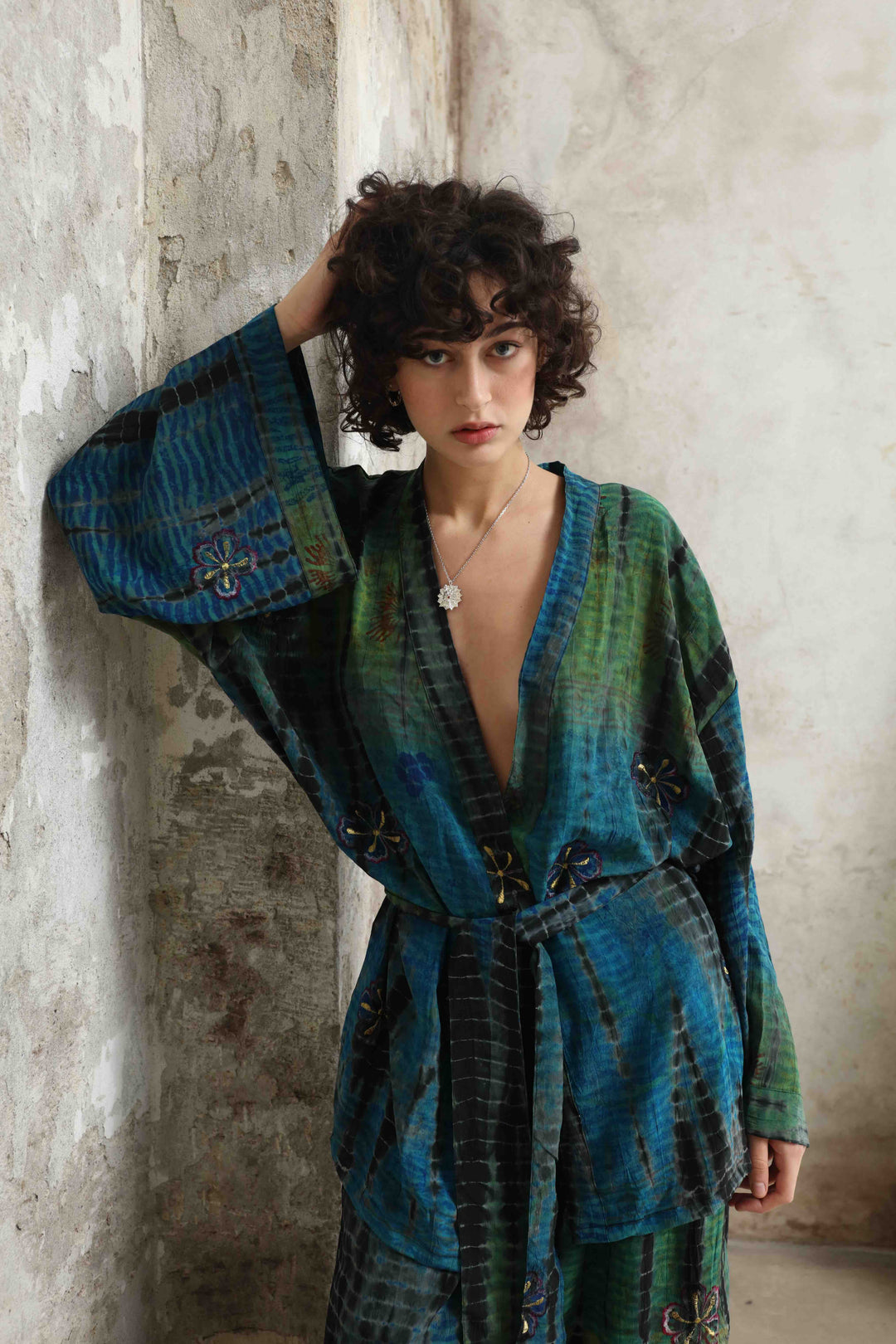 Model is wearing the Deep Teal Gorana Kimono Suit by House of Nomad Stories, featuring a relaxed silk kimono with matching belt and wide-leg trousers in a rich deep teal shade.