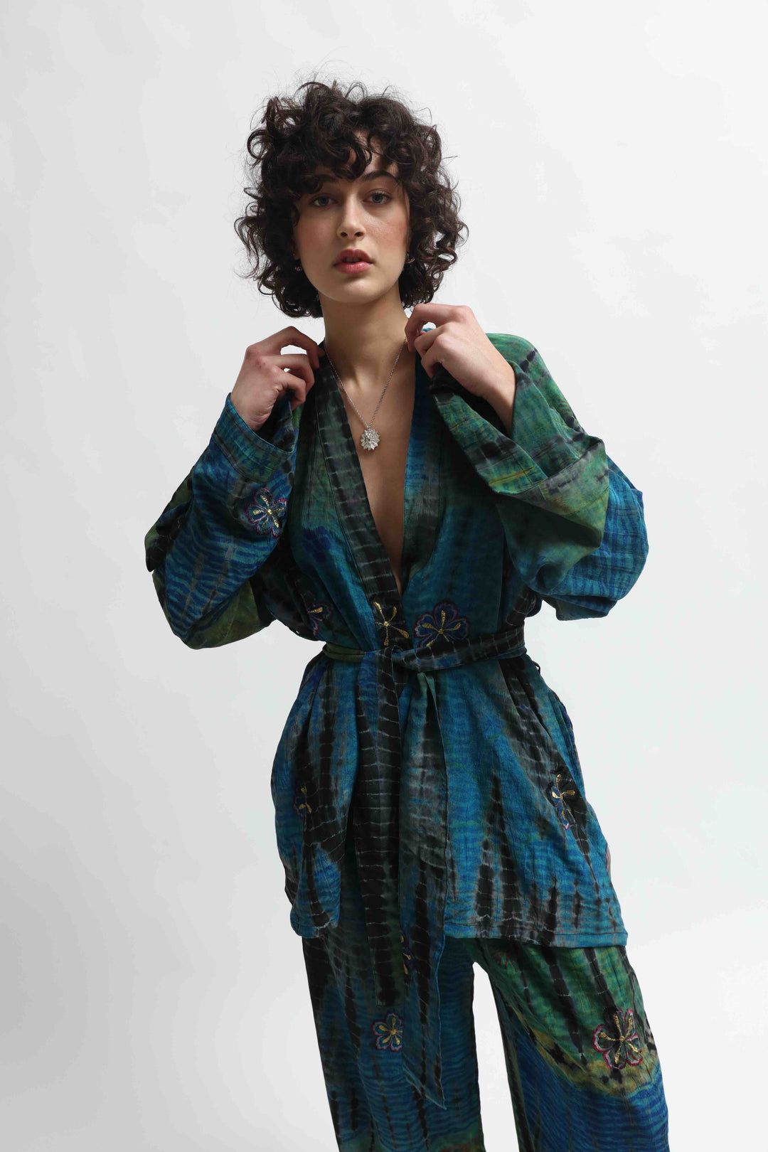 Model is wearing the Deep Teal Gorana Kimono Suit by House of Nomad Stories, featuring a relaxed silk kimono with matching belt and wide-leg trousers in a rich deep teal shade.