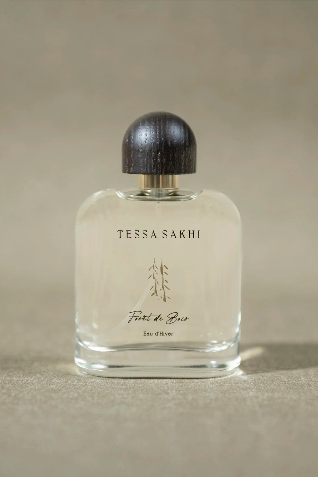 Bottle of Forêt de bois – Eau d’Hiver by Tessa Sakhi, a unisex woody and spicy Eau de Parfum with notes of juniper, cedar, tobacco, and ambergris. A sophisticated and mysterious fragrance curated by House of Nomad Stories.