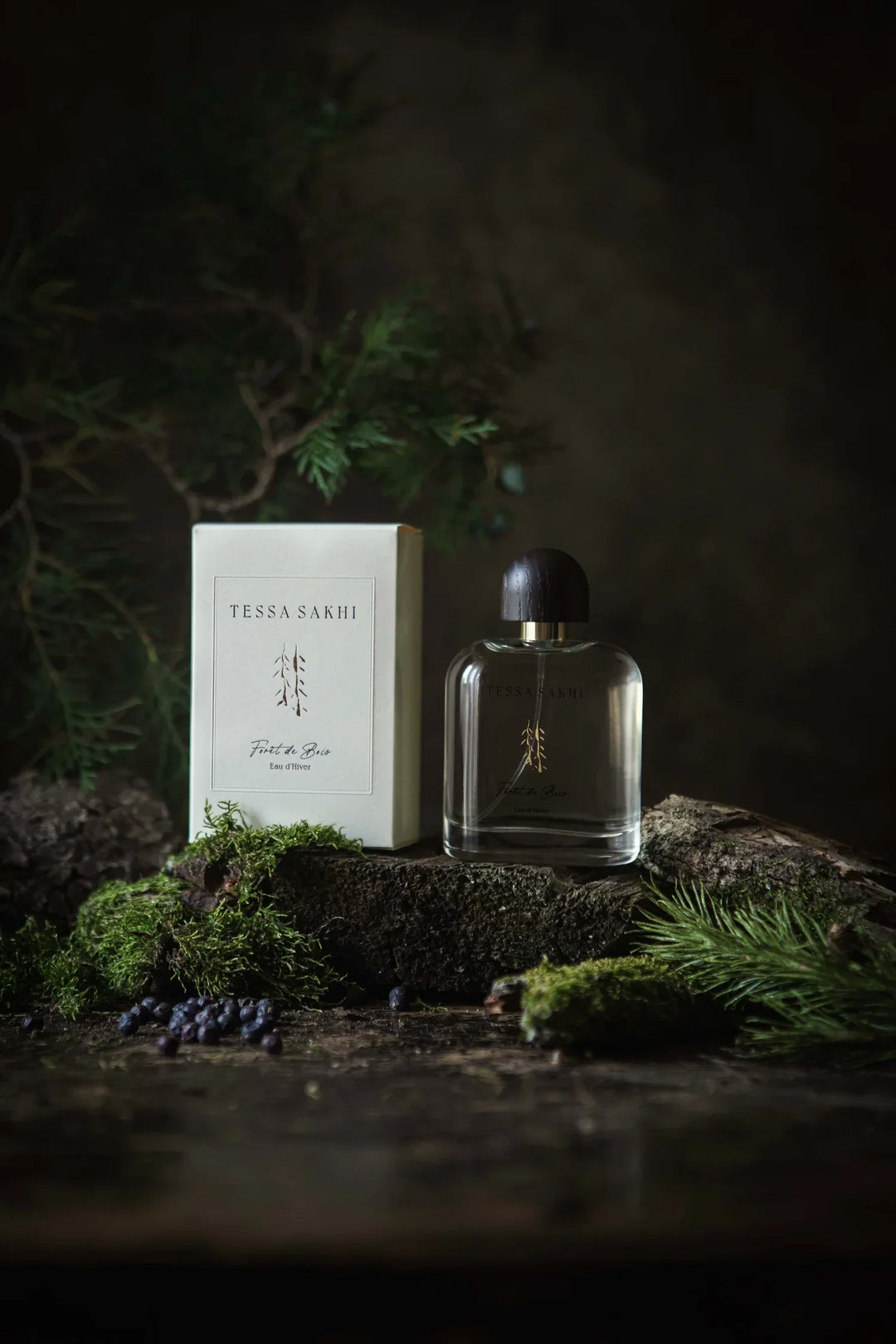 Bottle of Forêt de bois – Eau d’Hiver by Tessa Sakhi, a unisex woody and spicy Eau de Parfum with notes of juniper, cedar, tobacco, and ambergris. A sophisticated and mysterious fragrance curated by House of Nomad Stories.
