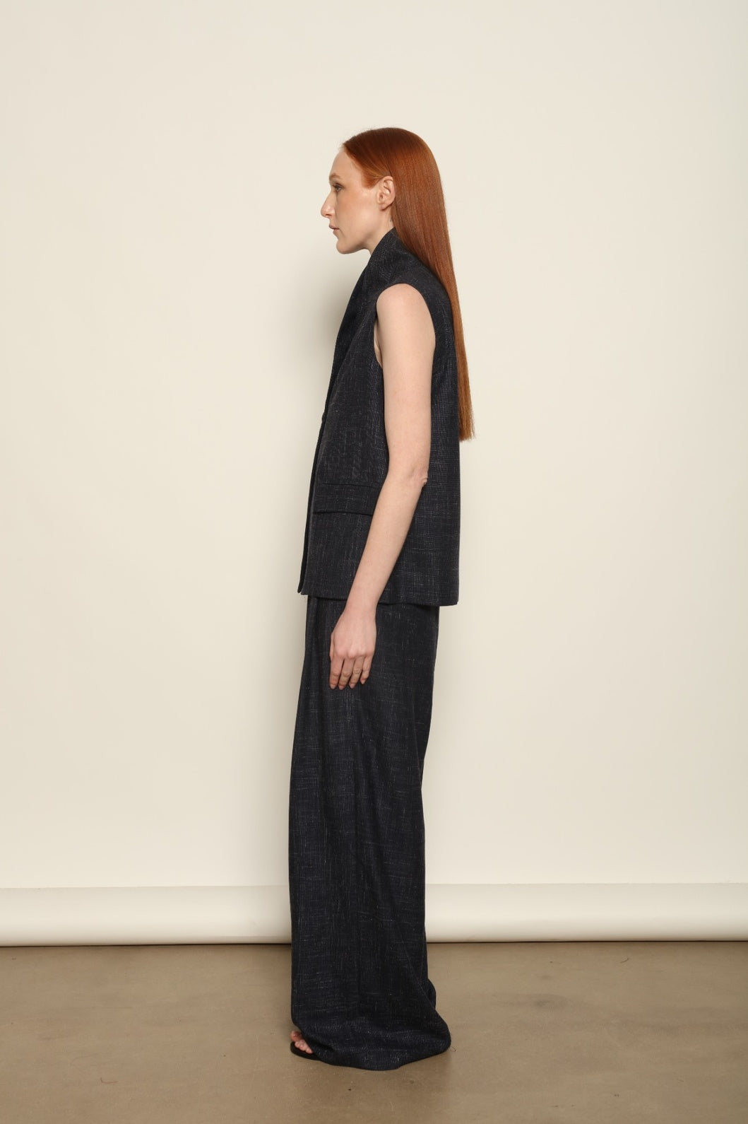 Model is wearing the Franca night blue and white gilet from the House of Woven Stories selection, a women’s tailored waistcoat made in Italy in Piedmont with a softly structured silhouette, designed for fluid layering and ethical contemporary fashion.