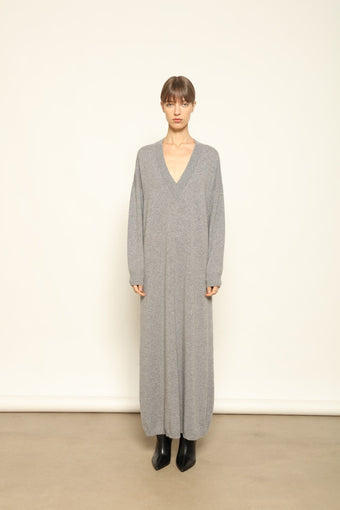 Model is wearing the Graphite Katharina V-Neck Cashmere Maxi Dress by House of Nomad Stories, made from 100% pure Inner Mongolia cashmere, featuring a soft, breathable, warm knit with a long flowing silhouette, deep V-neckline, and timeless ethical luxury craftsmanship