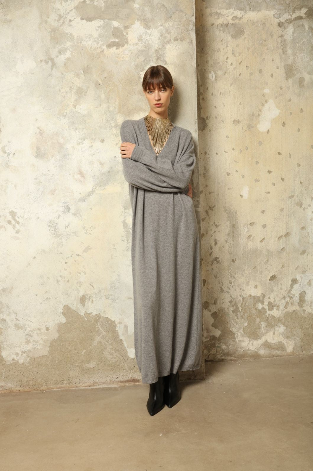 Model is wearing the Graphite Katharina V-Neck Cashmere Maxi Dress by House of Nomad Stories, made from 100% pure Inner Mongolia cashmere, featuring a soft, breathable, warm knit with a long flowing silhouette, deep V-neckline, and timeless ethical luxury craftsmanship