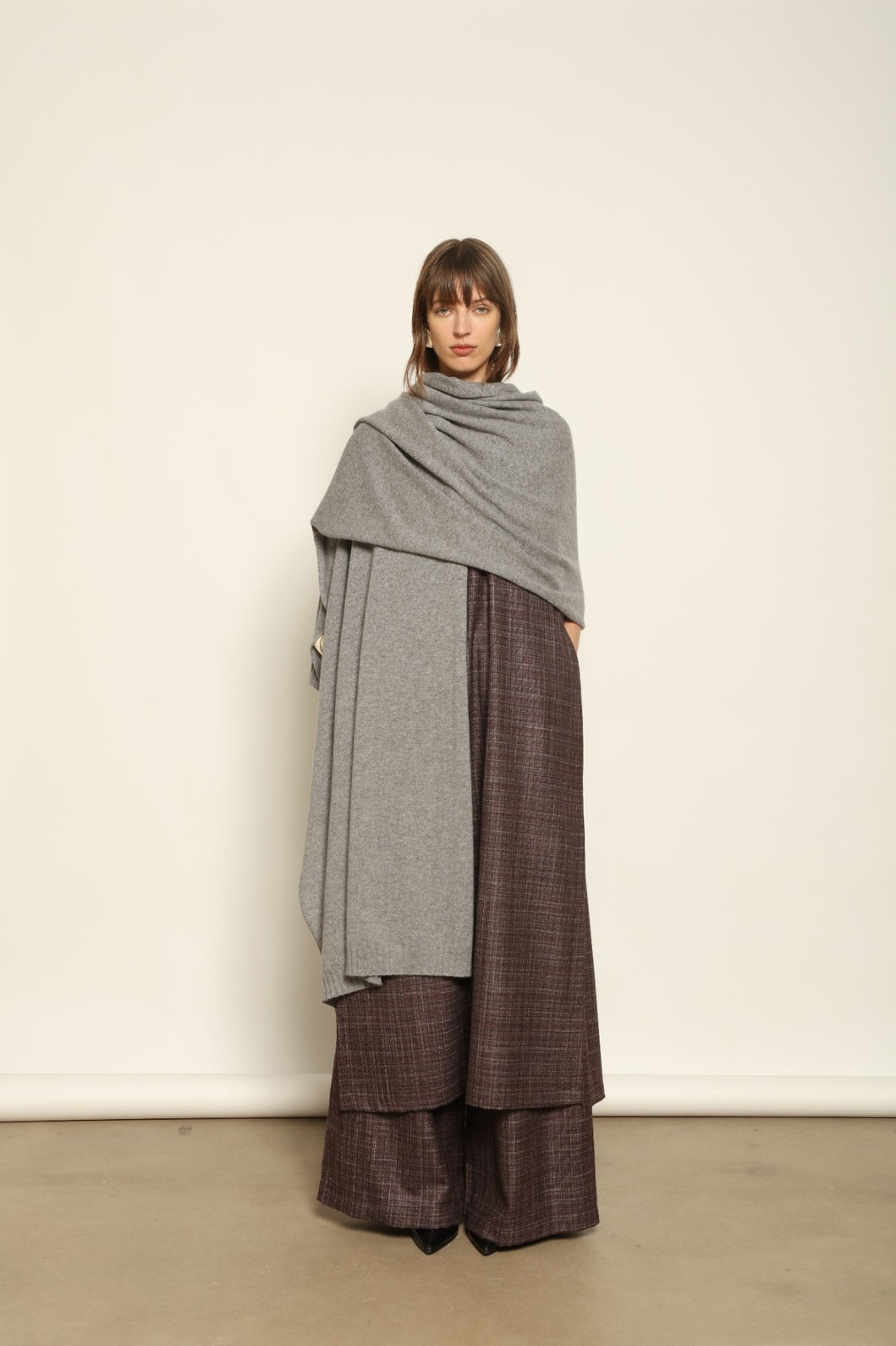 Model wearing the Graphite Leni Cashmere Scarf by House of Nomad Stories, made from 100% pure Inner Mongolia cashmere, featuring a soft graphite color, lightweight drape, smooth texture, lasting warmth, and sustainable luxury craftsmanship