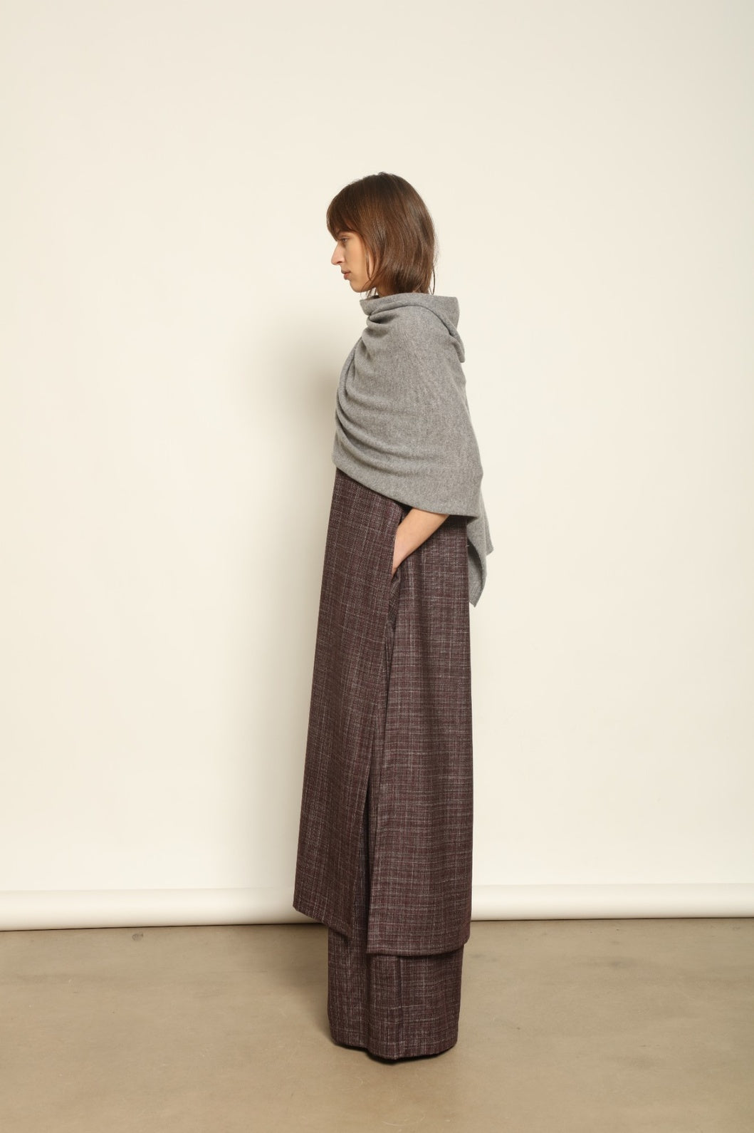 Model wearing the Graphite Leni Cashmere Scarf by House of Nomad Stories, made from 100% pure Inner Mongolia cashmere, featuring a soft graphite color, lightweight drape, smooth texture, lasting warmth, and sustainable luxury craftsmanship