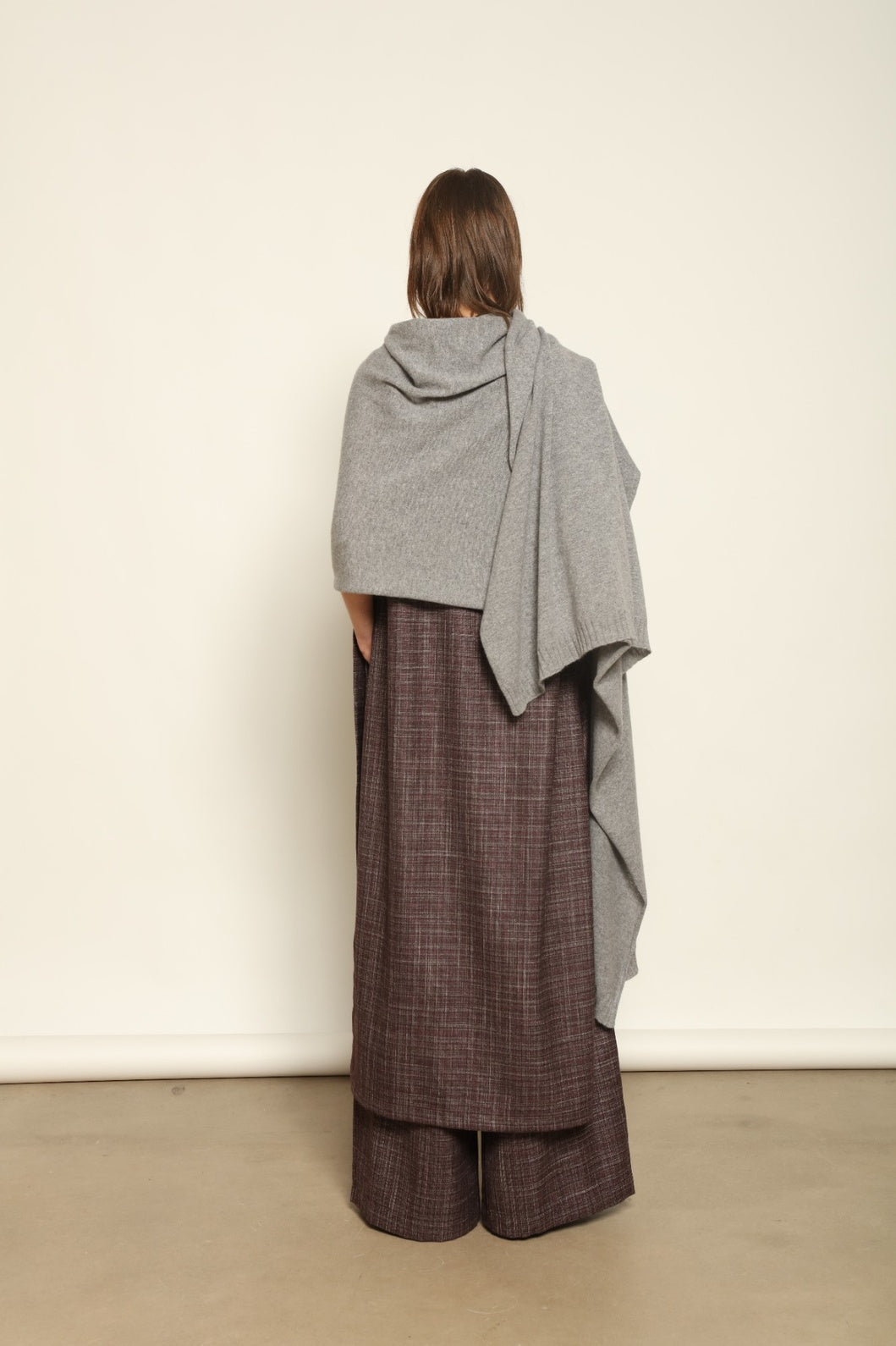 Model wearing the Graphite Leni Cashmere Scarf by House of Nomad Stories, made from 100% pure Inner Mongolia cashmere, featuring a soft graphite color, lightweight drape, smooth texture, lasting warmth, and sustainable luxury craftsmanship