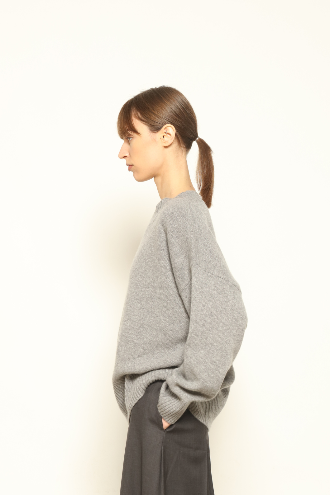 Model is wearing the graphite Noemi Round Neck Pullover by House of Nomad Stories, crafted from 100% pure Inner Mongolia cashmere, featuring ultra-soft, breathable, durable knitwear, relaxed fit, round neckline, and timeless ethical luxury design