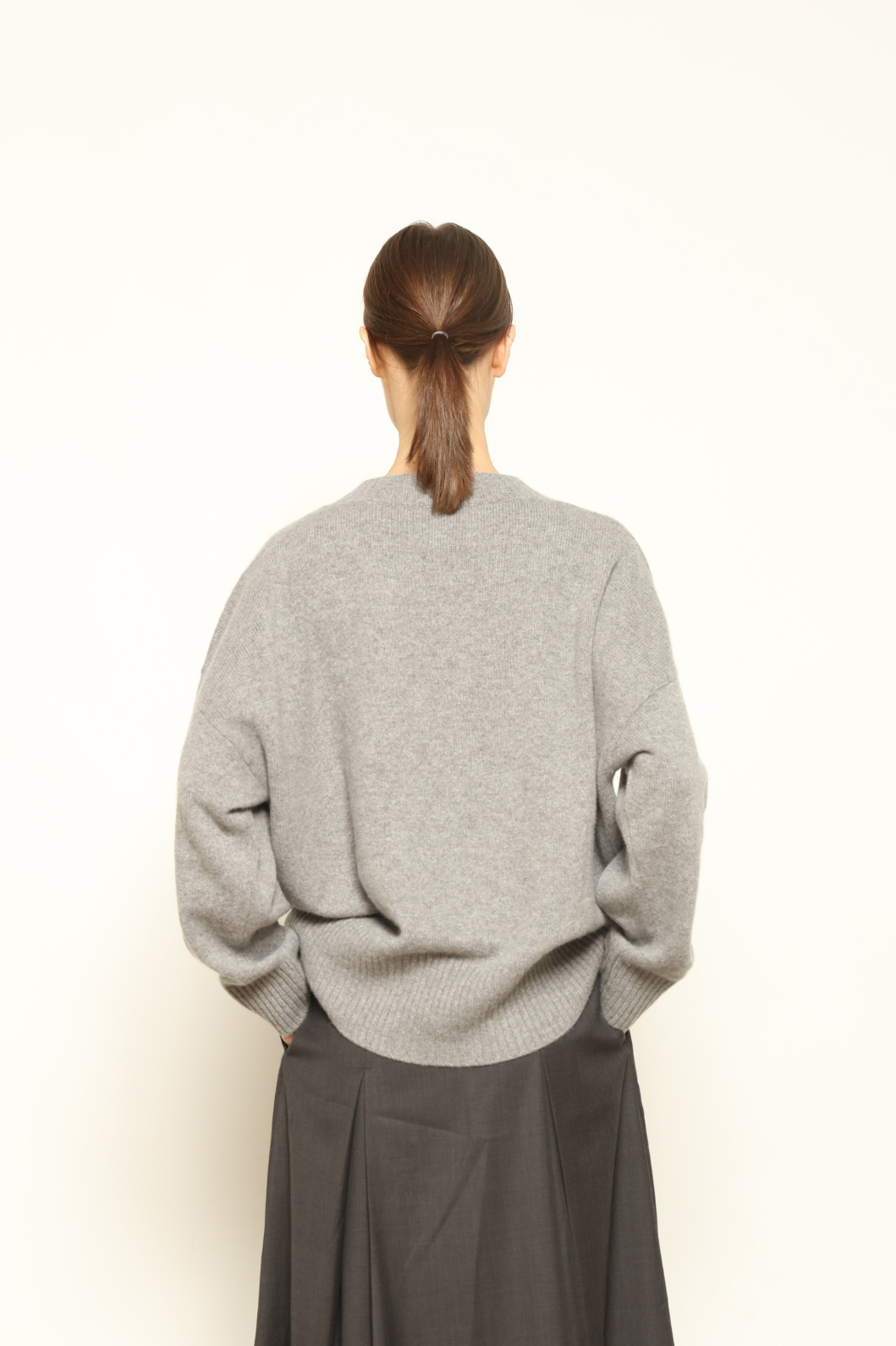 Model is wearing the graphite Noemi Round Neck Pullover by House of Nomad Stories, crafted from 100% pure Inner Mongolia cashmere, featuring ultra-soft, breathable, durable knitwear, relaxed fit, round neckline, and timeless ethical luxury design
