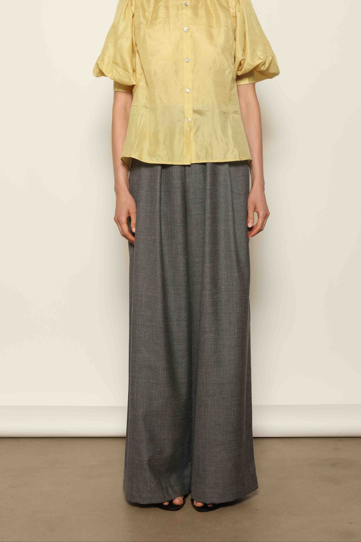 Grey Off-White Parigi Trousers by House of Nomad Stories, featuring a relaxed tailored silhouette, fluid lines, breathable Italian fabric, and an understated grey off-white tone.
