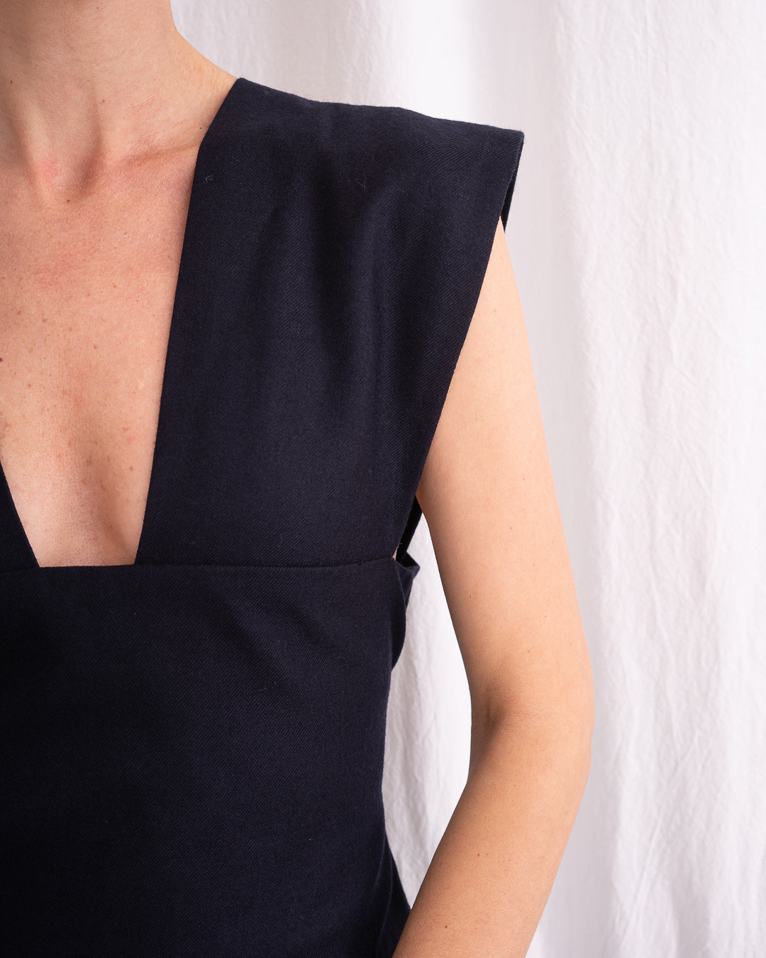 Model is wearing the Sarafan Pure New Wool Dress by Les Vacances d’Irina, a handmade navy merino wool dress with A-line silhouette, tie-back detail, horn buttons, and side pockets, available at House of Nomad Stories.