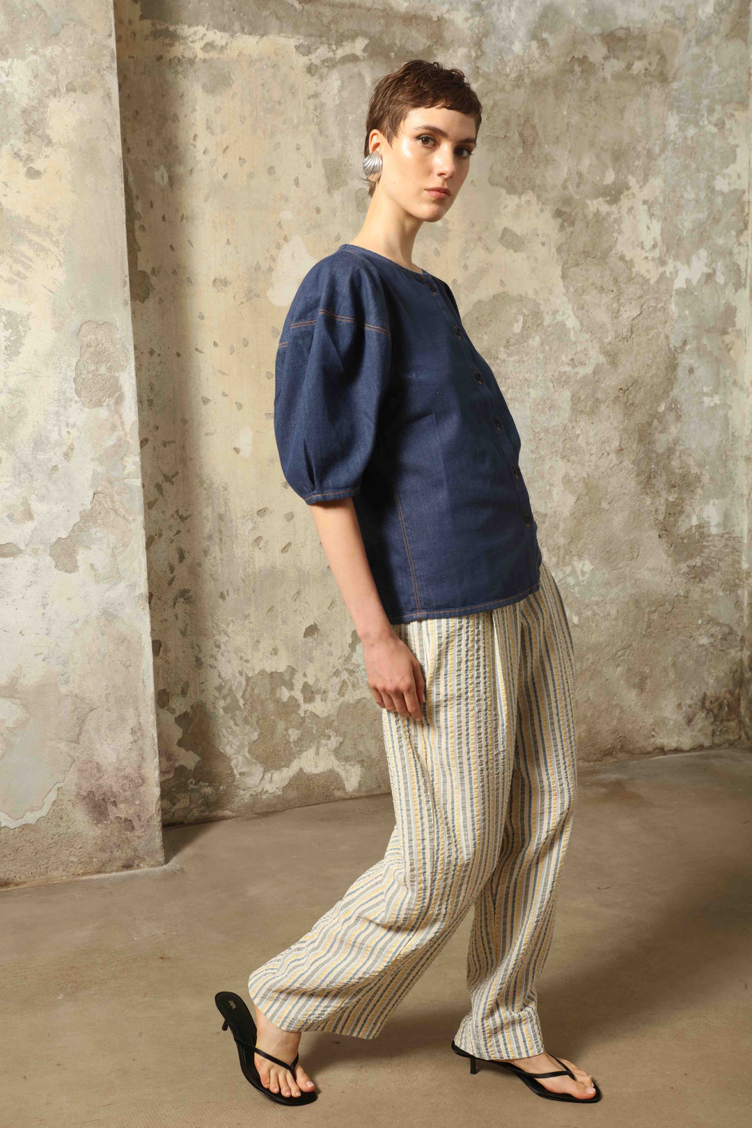 Model wearing the Blouse Bubble Brut in cotton denim by Happy Haus, featuring balloon sleeves, straight-cut silhouette, round neckline, and tobacco topstitching in a lightweight, breathable fabric.