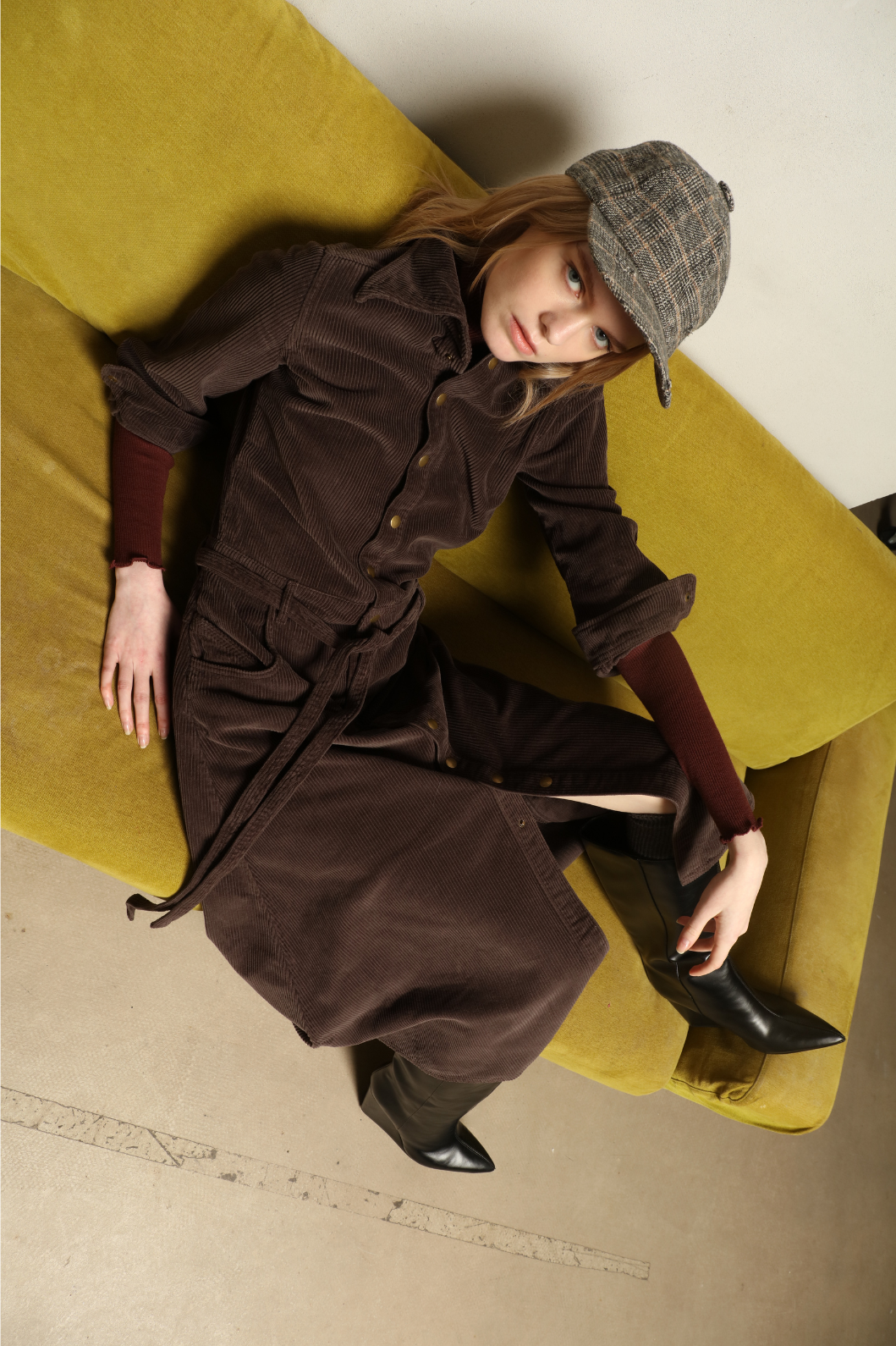 Model is wearing La Robe Trompe L’Oeil in Chocolate by Happy Haus, a corduroy cotton trompe-l’œil dress with removable belt, tulip-shaped pockets and brass snaps, curated in the House of Nomad Stories selection.