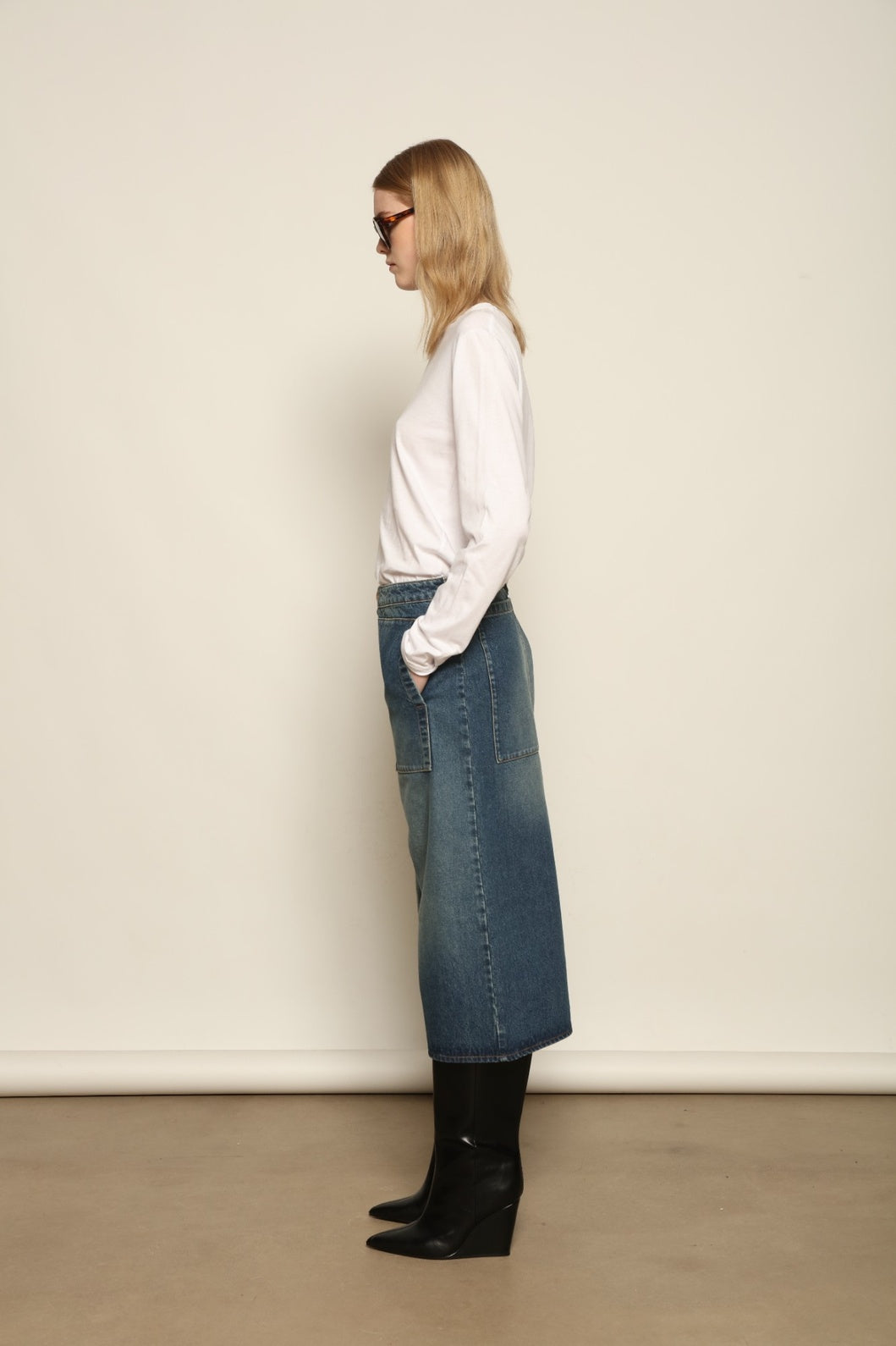 Model is wearing Le Bermuda 4 Poches by Happy Haus, organic denim mid-length bermuda shorts with four oversized patch pockets, curated in the House of Nomad Stories selection.