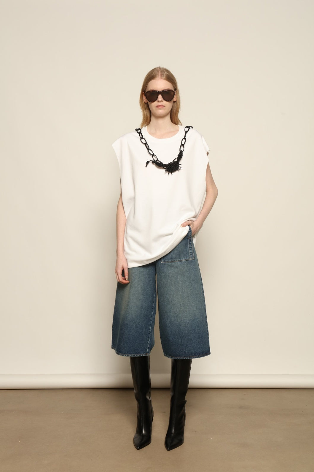 Model is wearing Le Bermuda 4 Poches by Happy Haus, organic denim mid-length bermuda shorts with four oversized patch pockets, curated in the House of Nomad Stories selection.