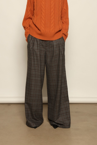 Model is wearing the Brown Check Parigi Pants by House of Nomad Stories, relaxed straight-leg Merino wool trousers with a soft brown check pattern, handcrafted in Italy.