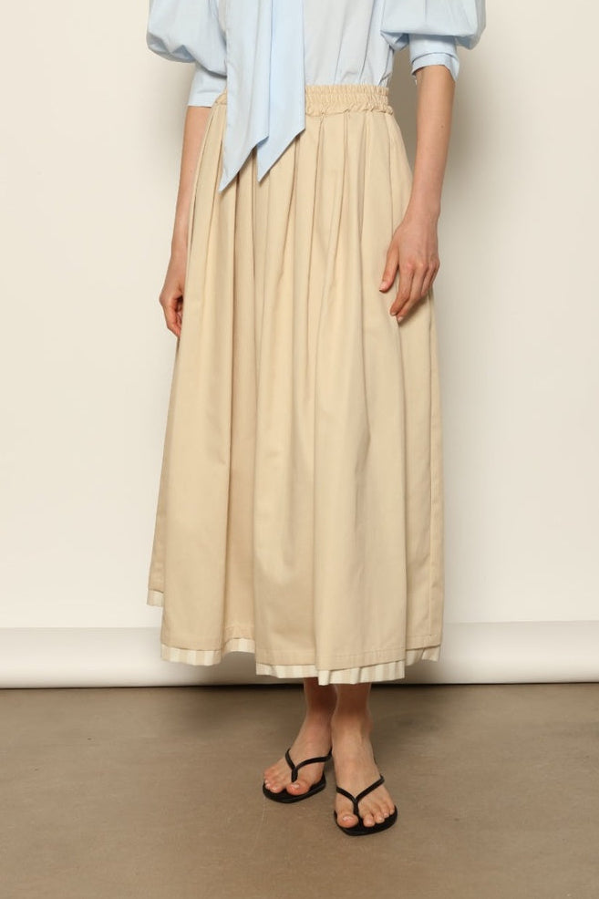 Model wearing the Seoul Camel Skirt by House of Nomad Stories, featuring a structured camel-toned fabric, high-waisted fit, and a clean tailored silhouette with defined architectural lines.