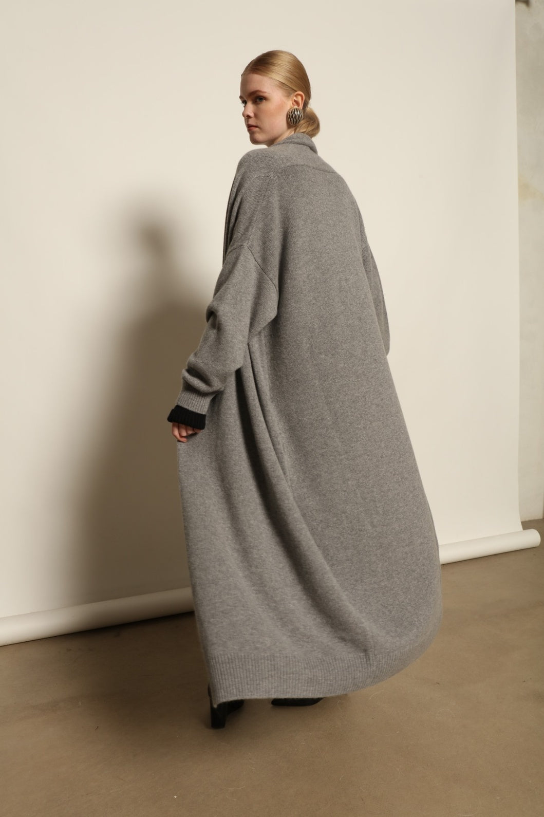 Model is wearing the Graphite Paula Cashmere Coat by House of Nomad Stories, a pure ethically sourced cashmere coat in deep graphite with fluid open-front silhouette and refined soft drape.