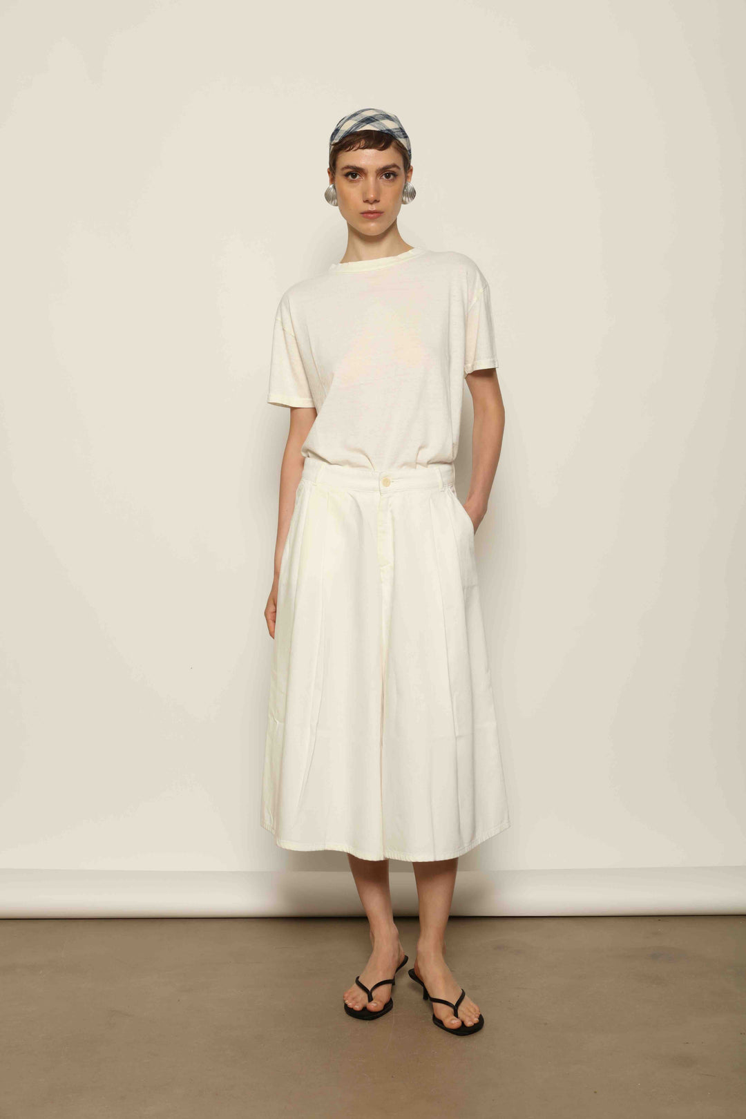 Model wearing the La Jupe Culotte in Blanc Cassè by Happy Haus from the House of Nomad Stories collection, featuring premium Japanese denim, a high-waisted fit, wide-leg silhouette, and elegant ankle-length design.